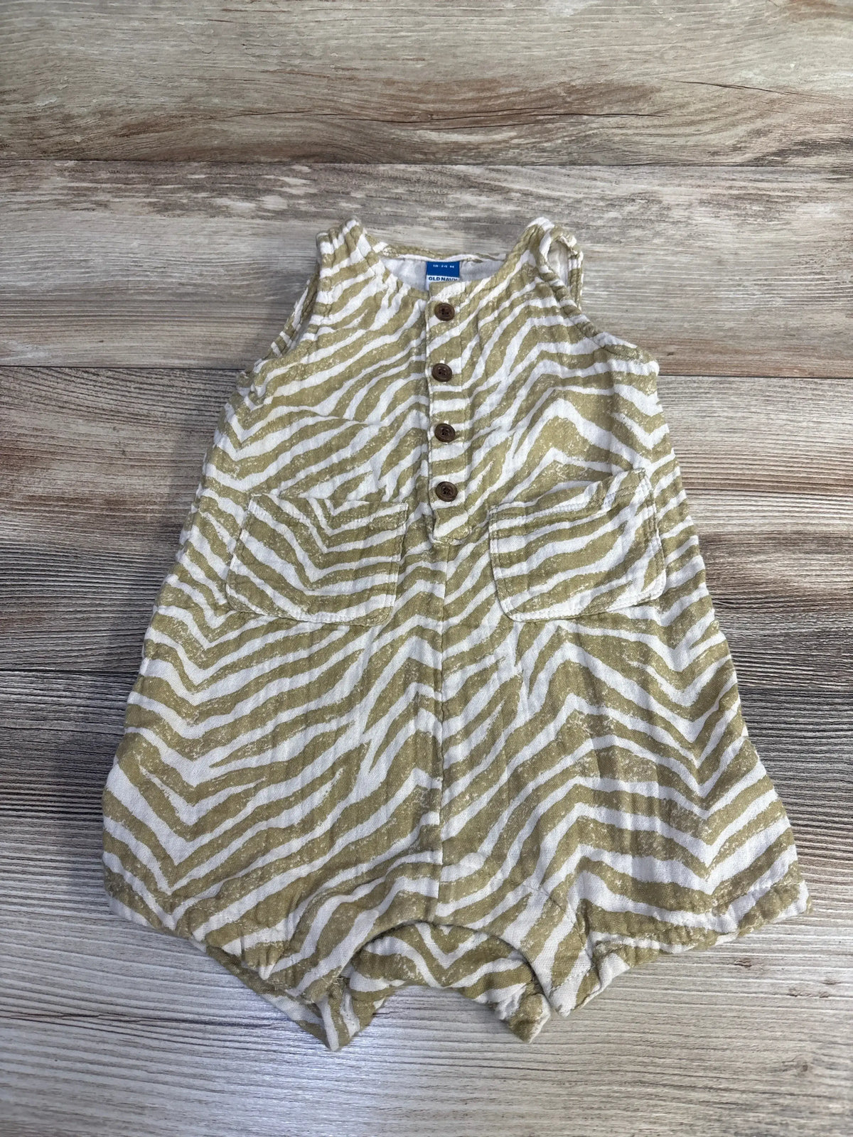 Front view of Old Navy tan zebra henley romper, size 18-24m, with button front and pockets on wood background