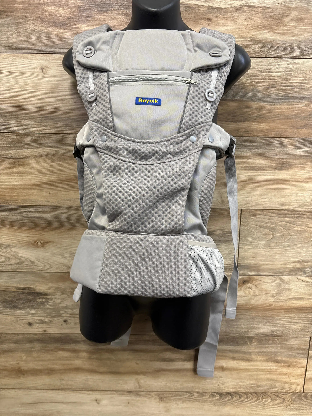 Front view of Beyoik all-position baby carrier showcasing gray breathable mesh and zippered pocket on a mannequin