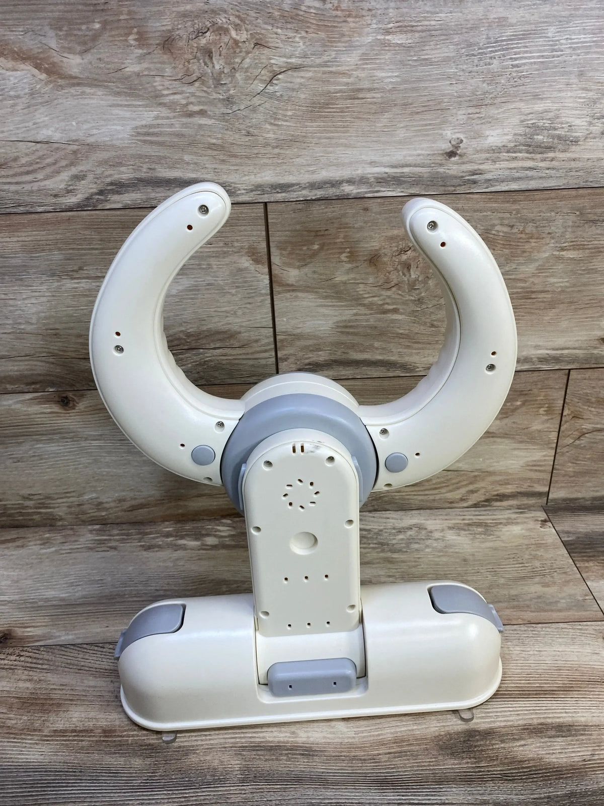 Front view of IvyWind wall-mounted baby shower stand showcasing U-shaped cradle and foldable base on wood background
