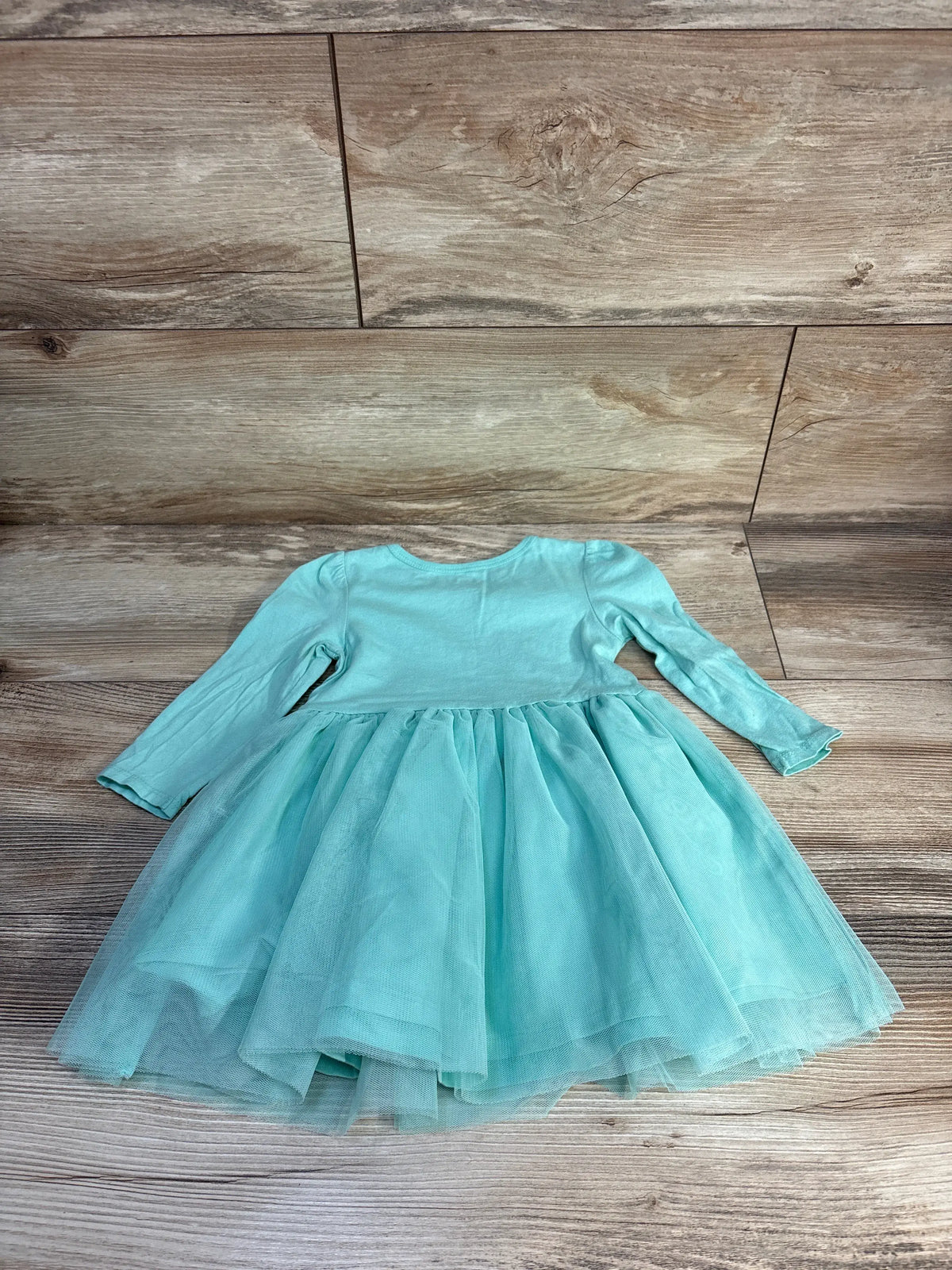 Front view of Carter’s Hello Kitty long sleeve tulle dress in teal, showcasing full tulle skirt and cotton body on wood flooring