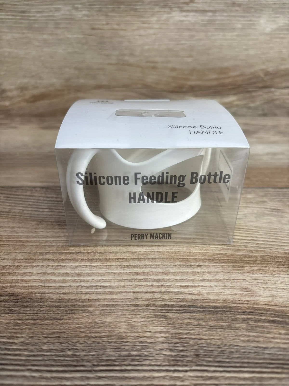 Front view of white silicone bottle handle in clear box showing dual curved handles and packaging text on wood