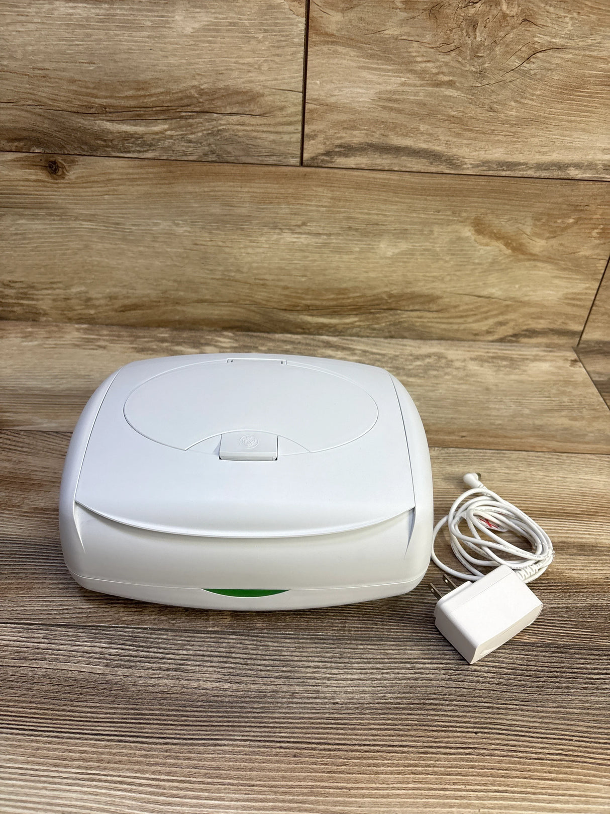 Front view of Prince Lionheart Ultimate Wipes Warmer showing flip top lid and included power adapter on wood tabletop background