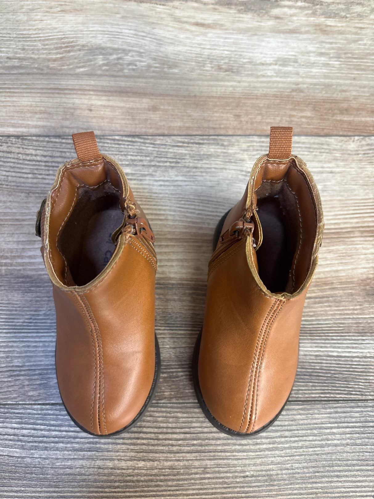 Pair of brown toddler leather boots on wooden floor