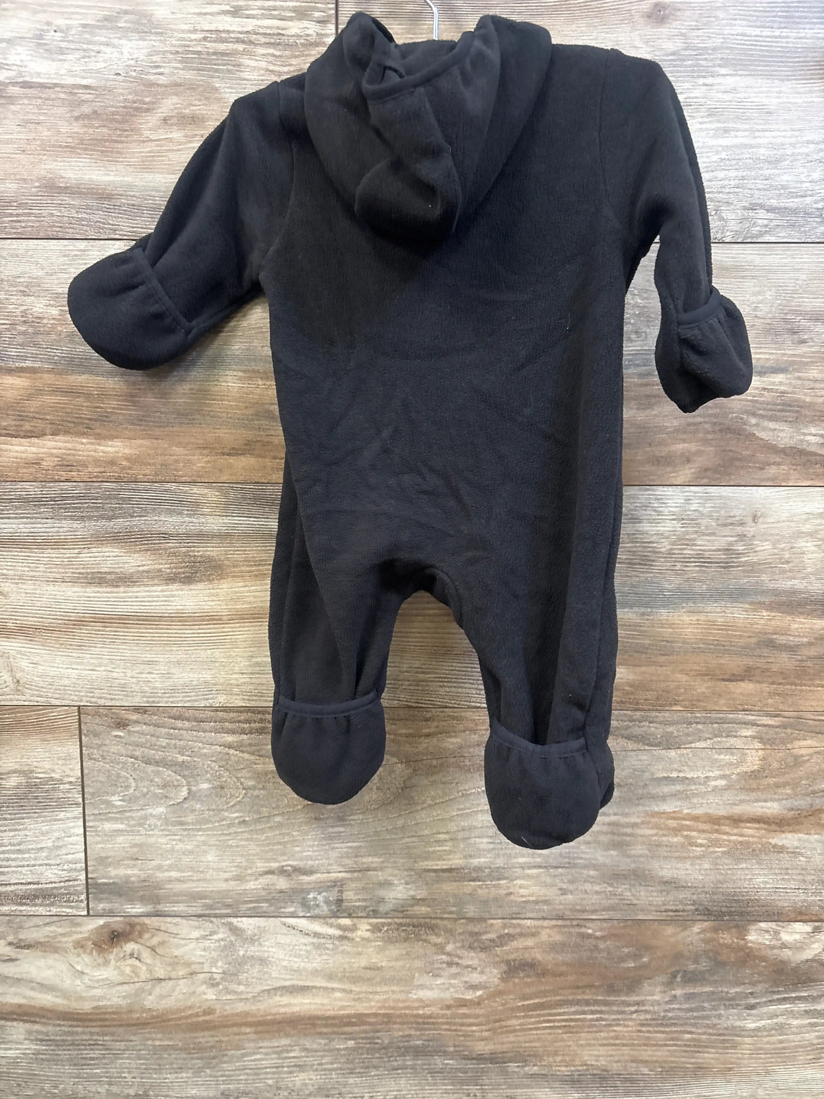 Front view of Wonder Nation black fleece bunting with hood, enclosed mittens and foot covers on a wood floor