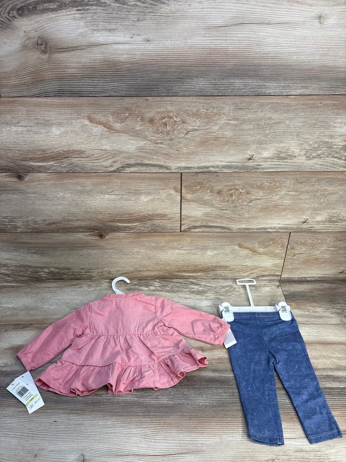 Toddler outfit with pink long-sleeve ruffled top and navy blue leggings on hanger