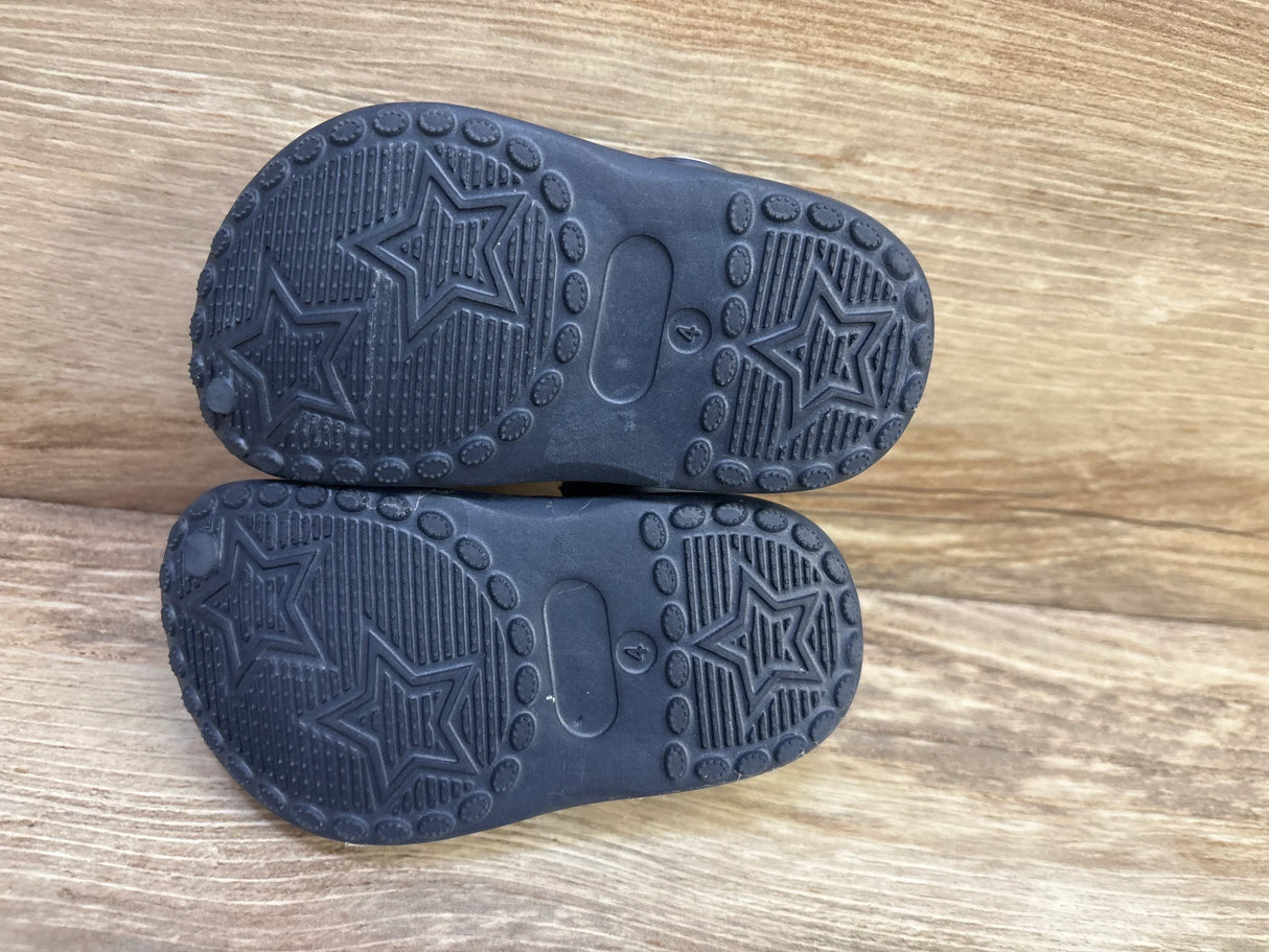Top view of Koala Kids toddler clogs showcasing star-pattern tread on soles with molded size 4 on a wood background