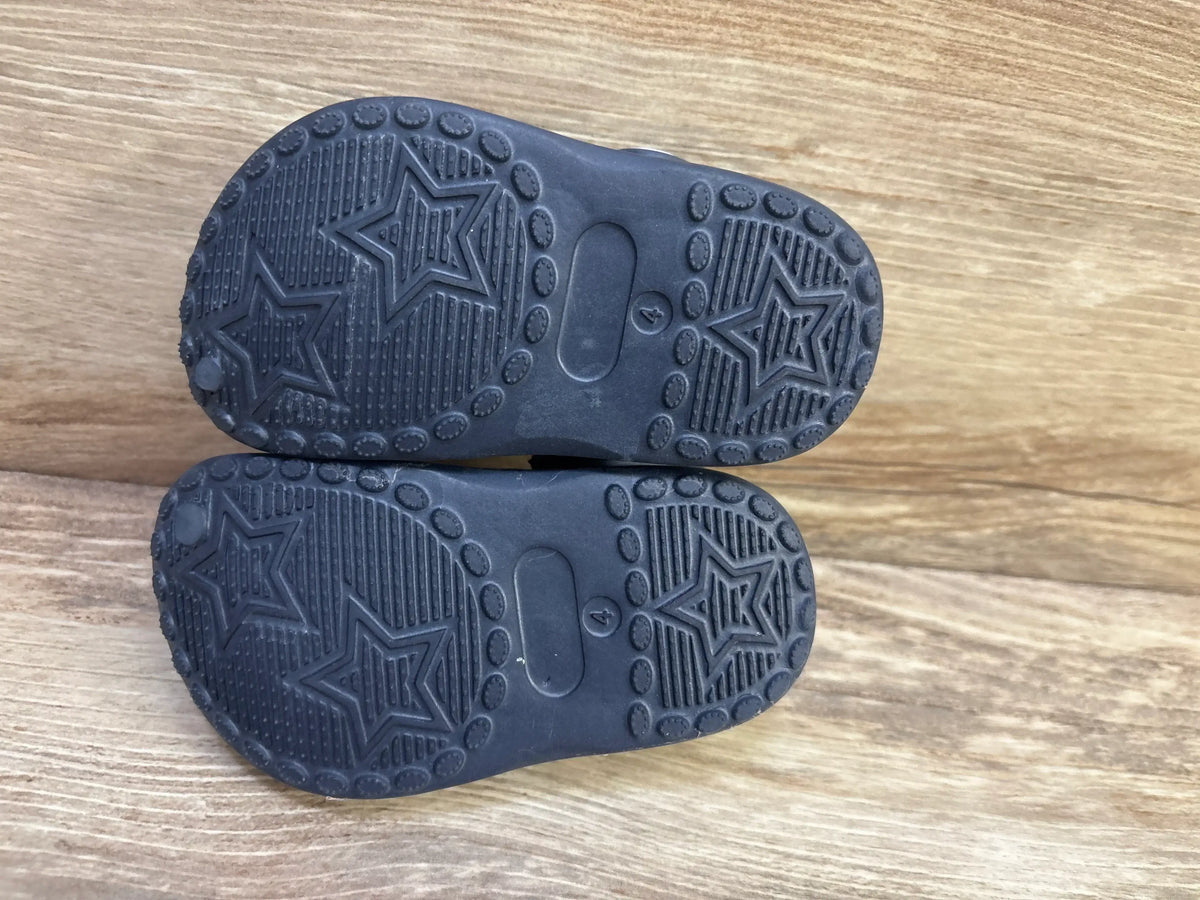 Top view of Koala Kids toddler clogs showcasing star-pattern tread on soles with molded size 4 on a wood background