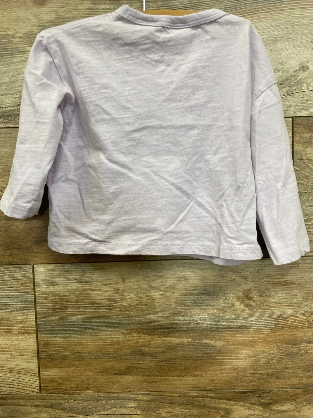 Back view of Zara Shirt in pale pink size 12-18m showcasing long sleeves and plain knit fabric on wood plank floor