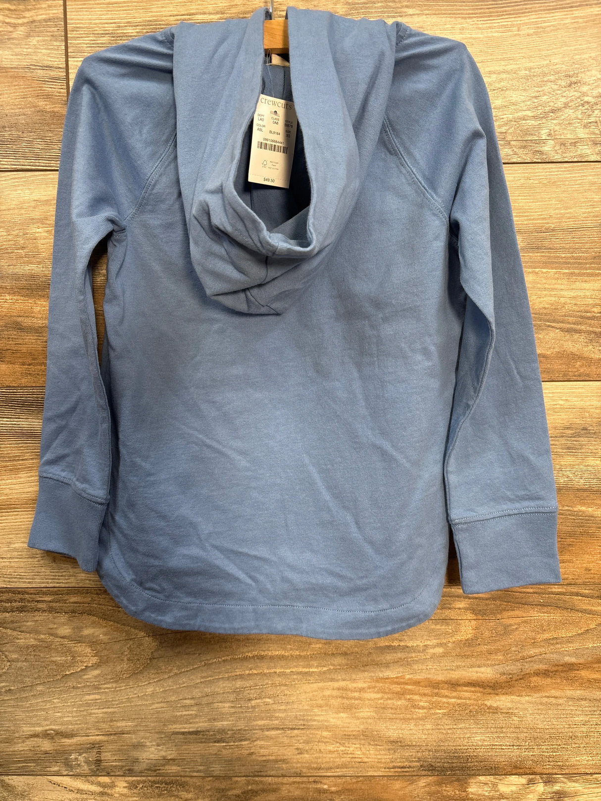 Light blue crewcuts hoodie with hood and long sleeves on wooden background