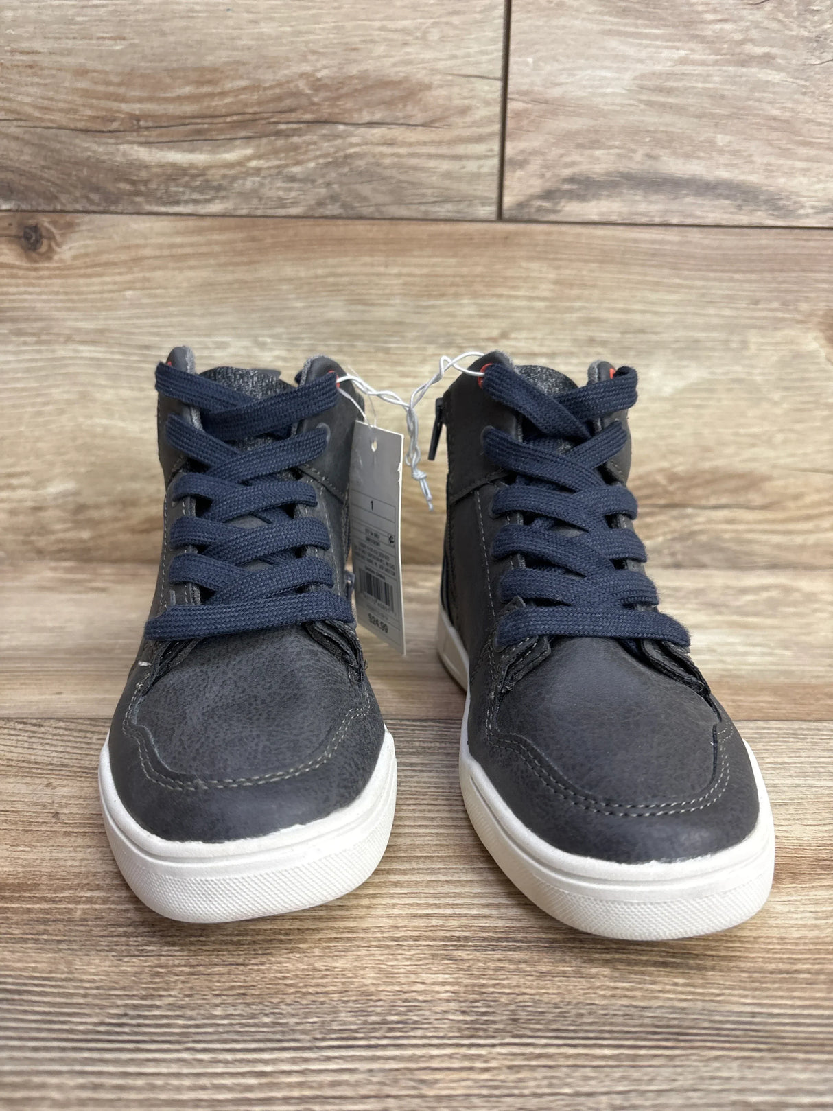 Toddler high-top sneakers in dark gray with navy laces and white soles on wood background