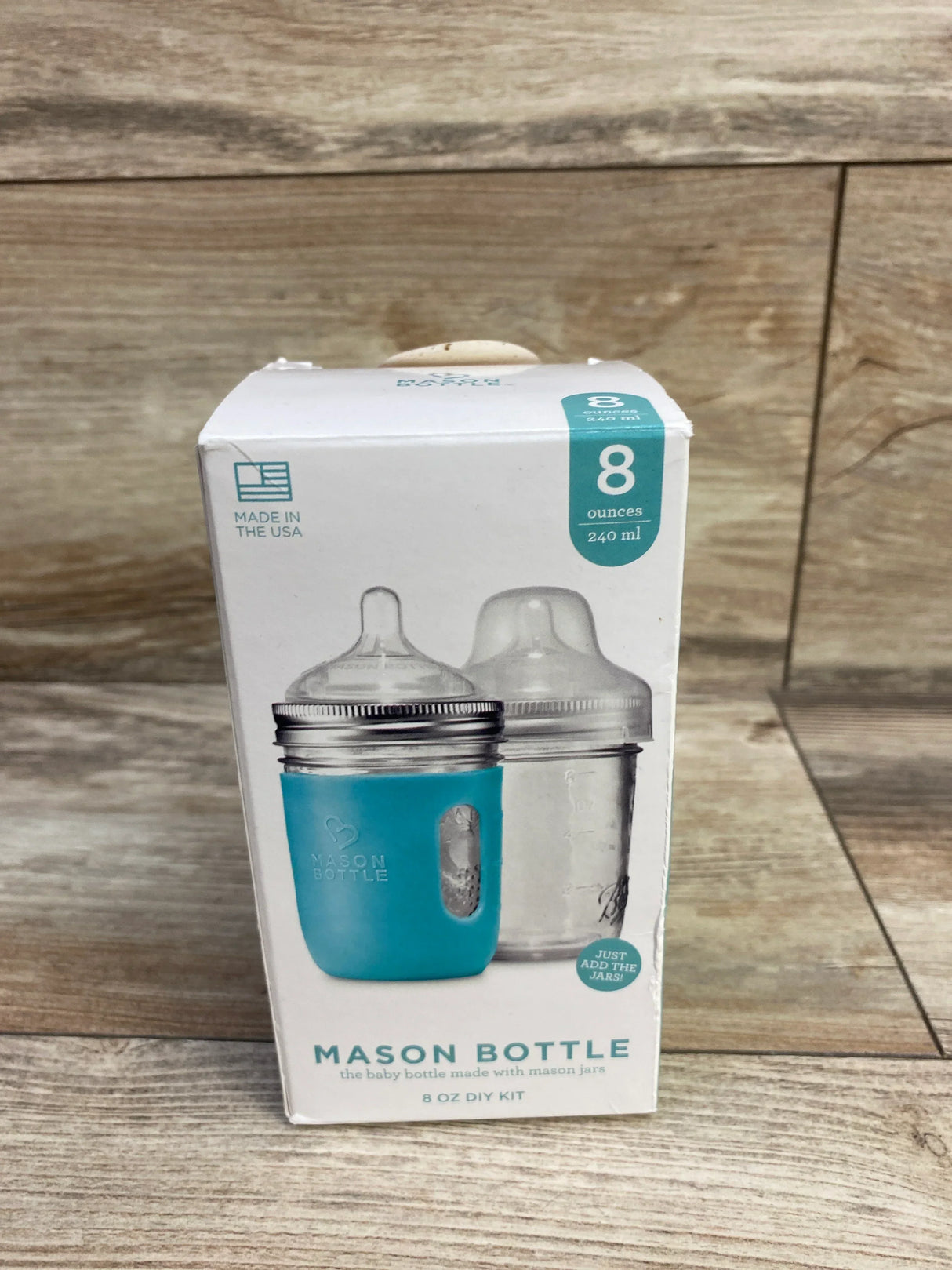 Front of Mason Bottle 8 oz kit box showing two mason-style baby bottles, one with blue silicone sleeve on wood background