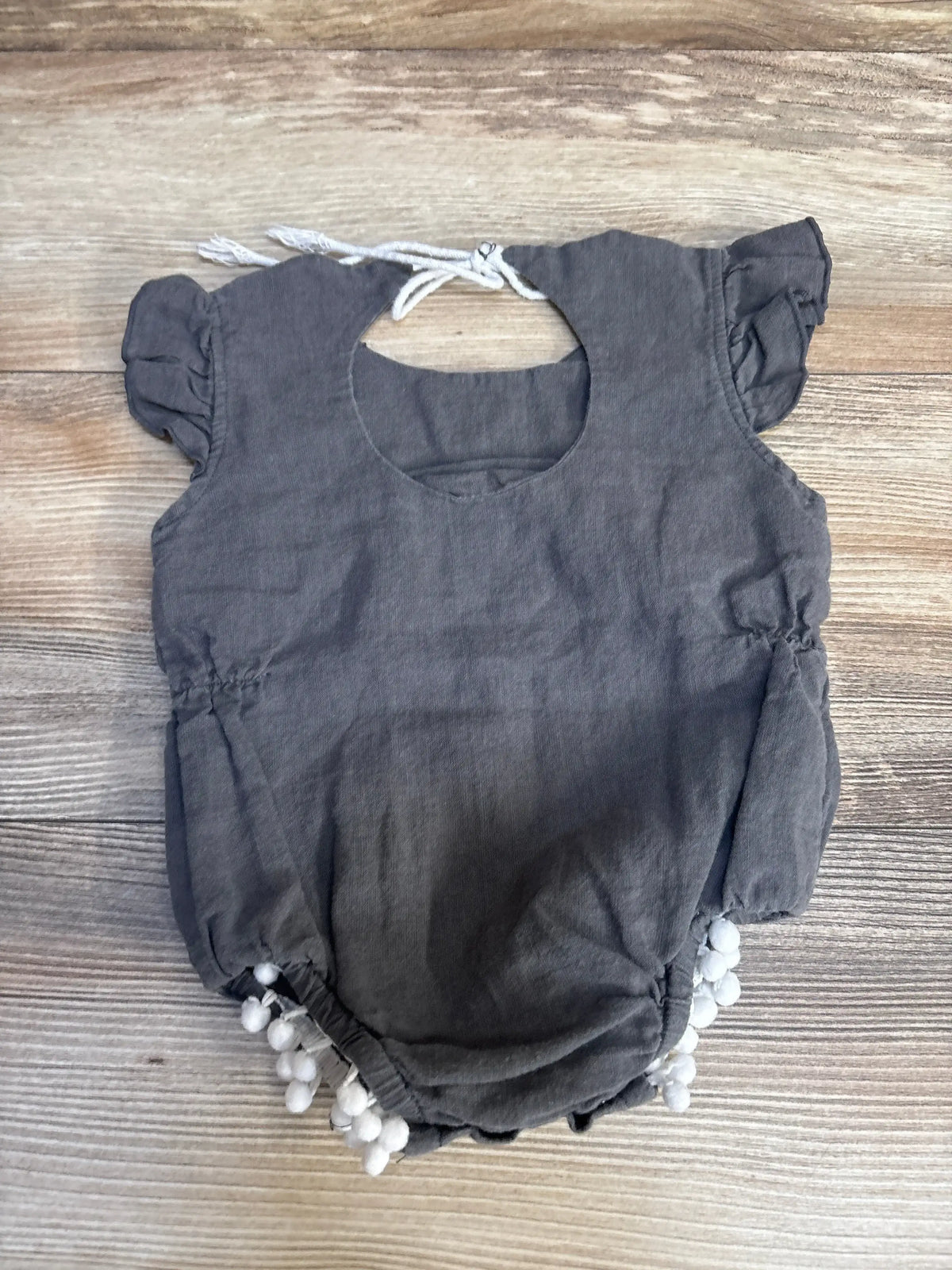 Gray baby romper with white pom-poms and ruffled sleeves, ideal for kids' clothing resale