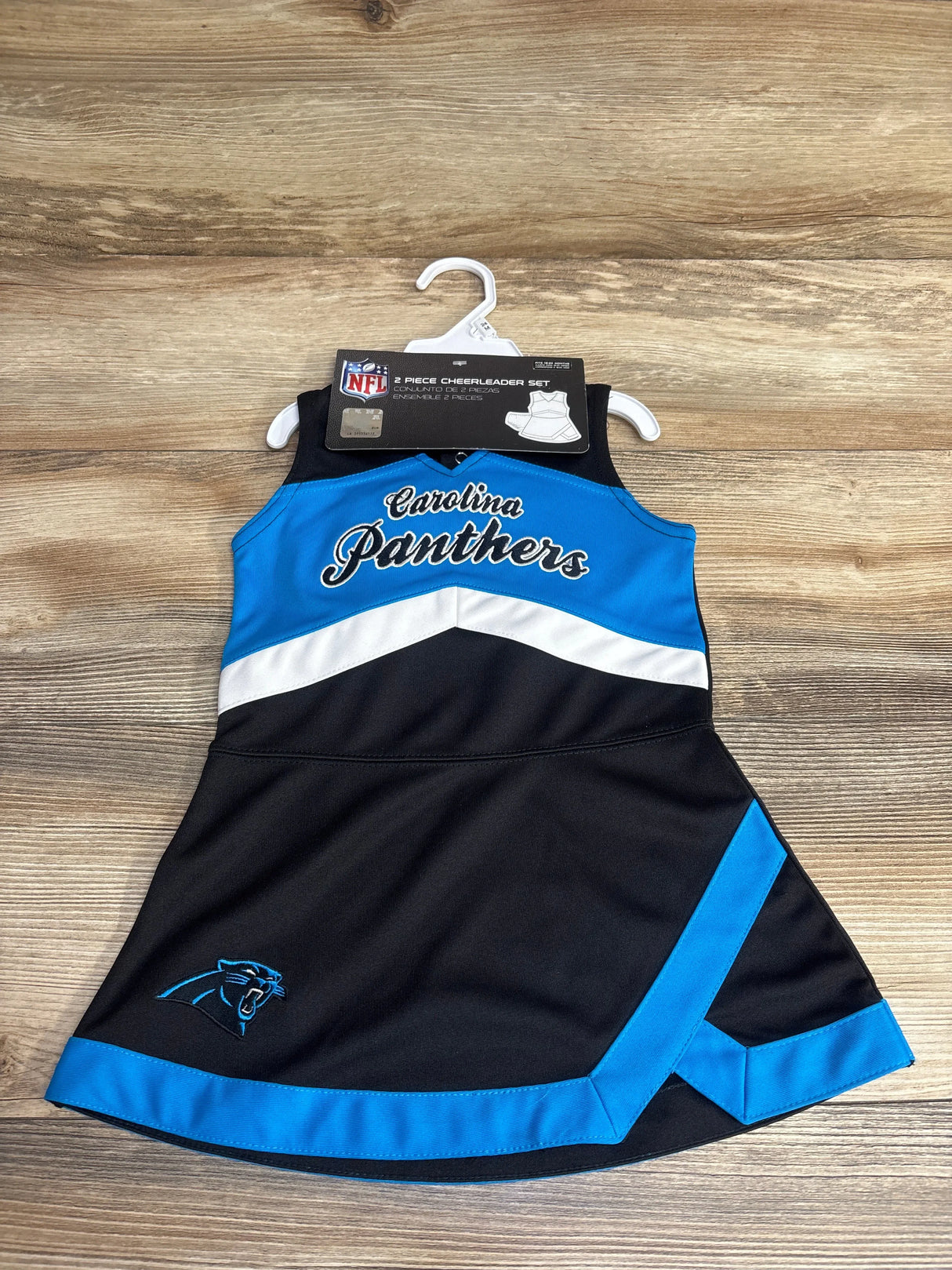 Carolina Panthers kids 2-piece cheerleader dress set in black and blue with team logo on wooden background