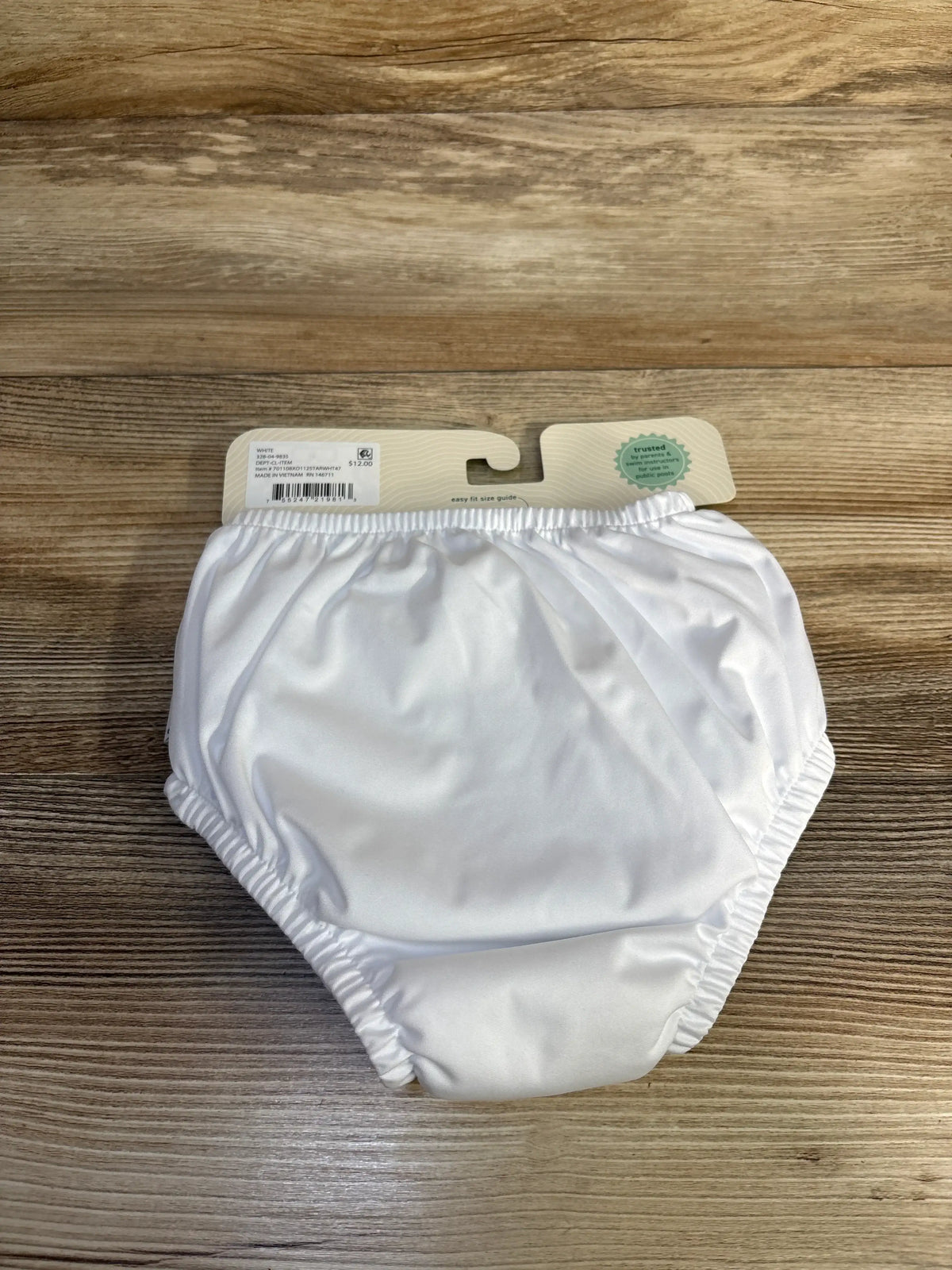 Front view of Green Sprouts eco pull-up swim diaper in white size 3T showcasing elastic leg and waist bands with wood tabletop background
