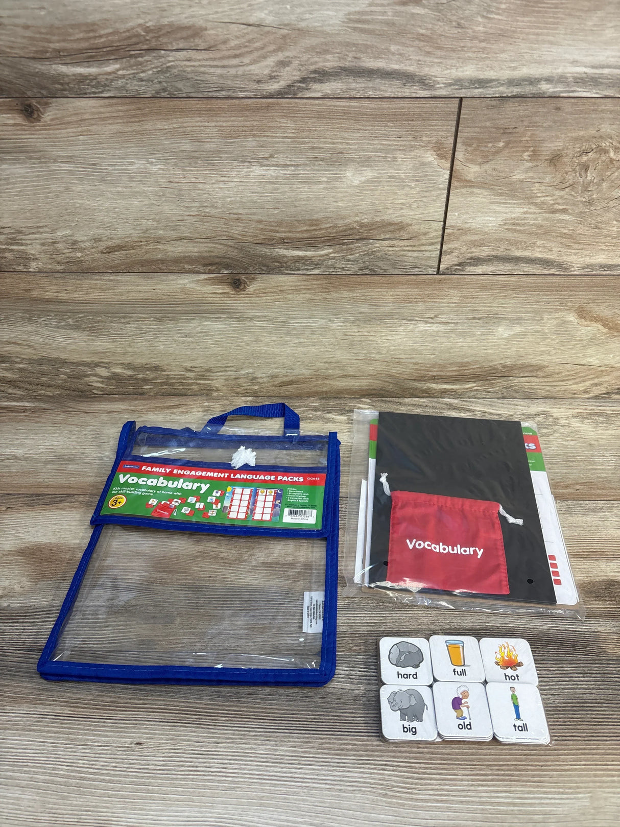Children's vocabulary language learning kit with flashcards and activity pack on wood background