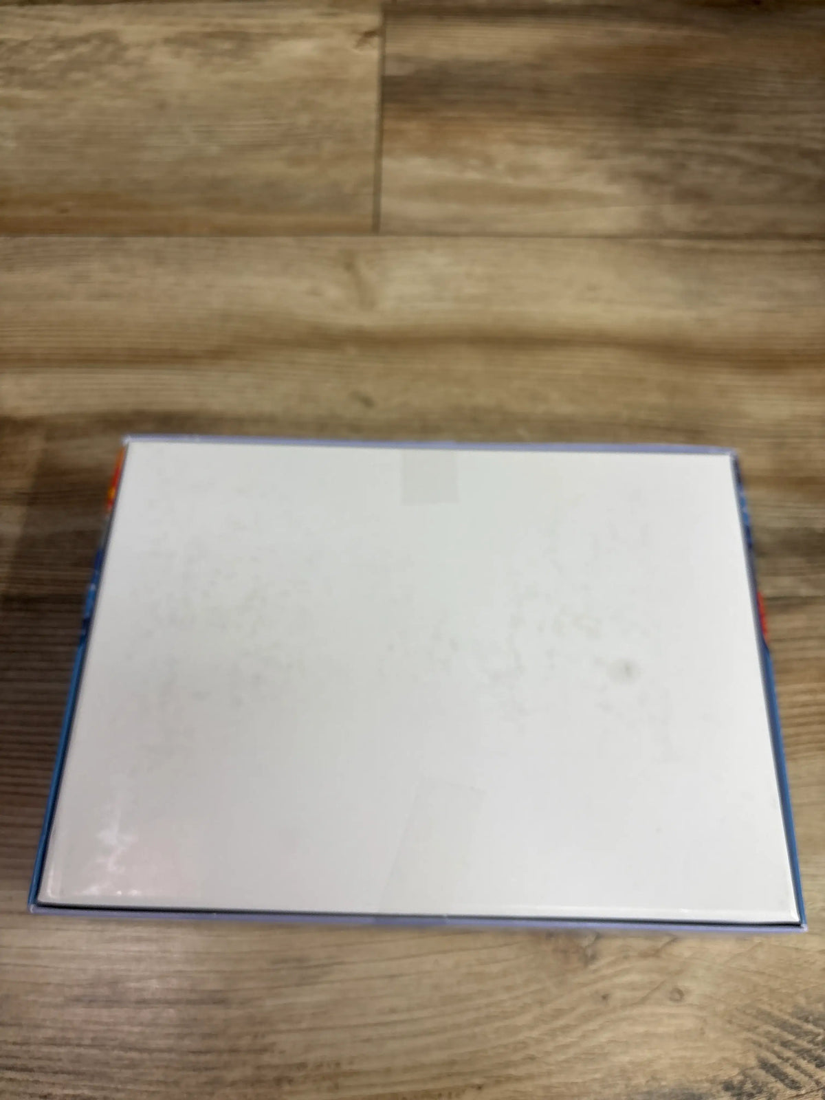 Back view of zhiseoyi 300pc Jigsaw Puzzle Dogs box showing its blank white back on a wooden surface