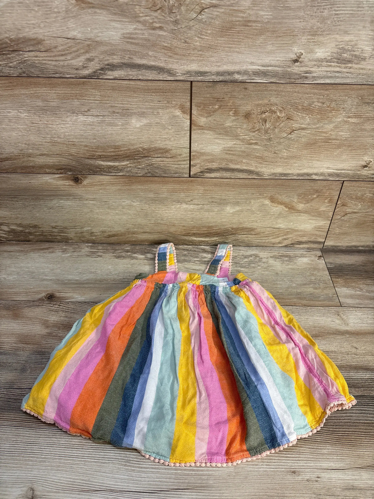 Front view of Tahari striped tank dress in multicolor showcasing tank straps and gathered skirt with a wood floor background
