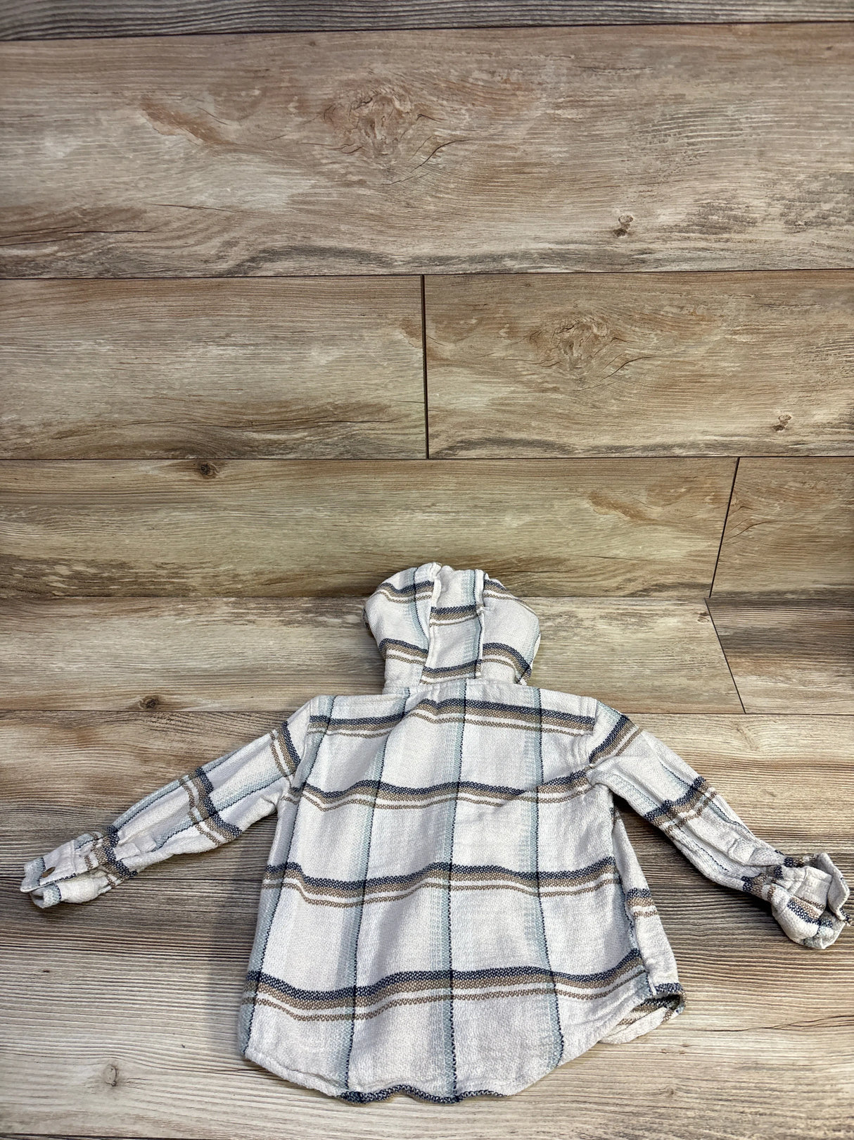 Back view of toddler hooded flannel shirt, beige plaid, size 3T on wood background