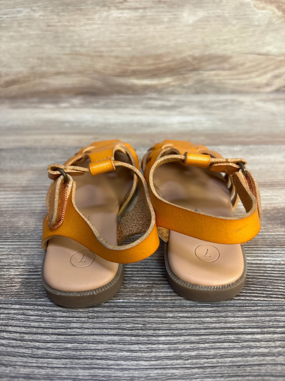 Rear view of Cat and Jack Ella ankle strap sandals in cognac size 7C showing velcro ankle straps and cushioned insoles on wood background