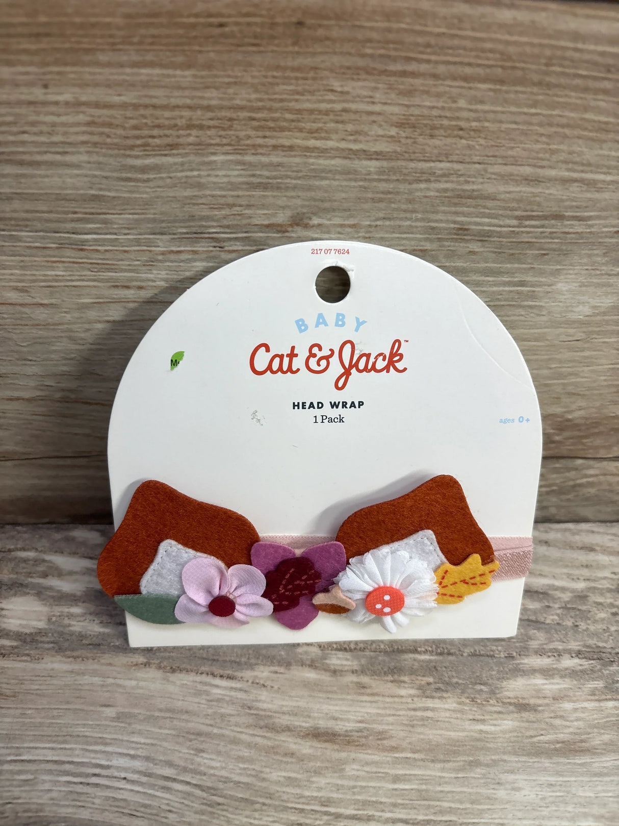 Cat & Jack baby head wrap with pink, white, and purple flower decorations on display card