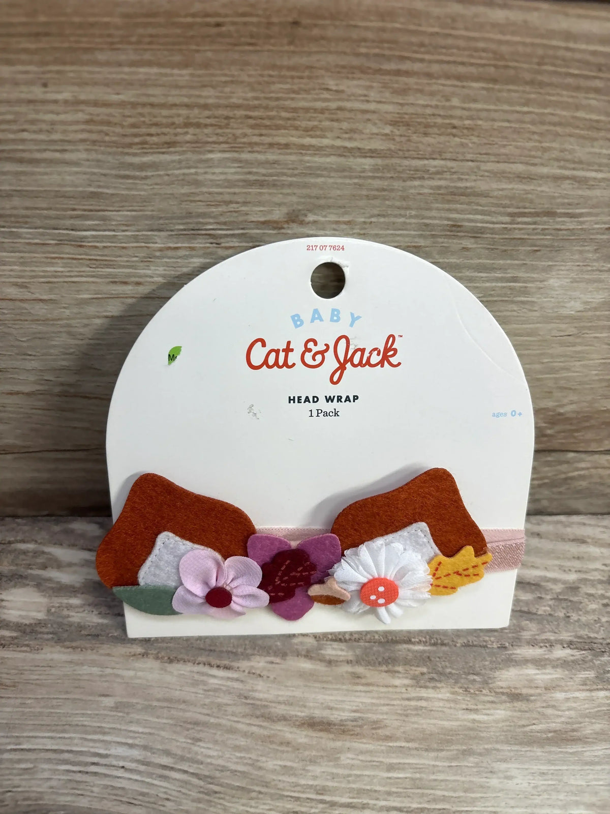 Cat & Jack baby head wrap with pink, white, and purple flower decorations on display card