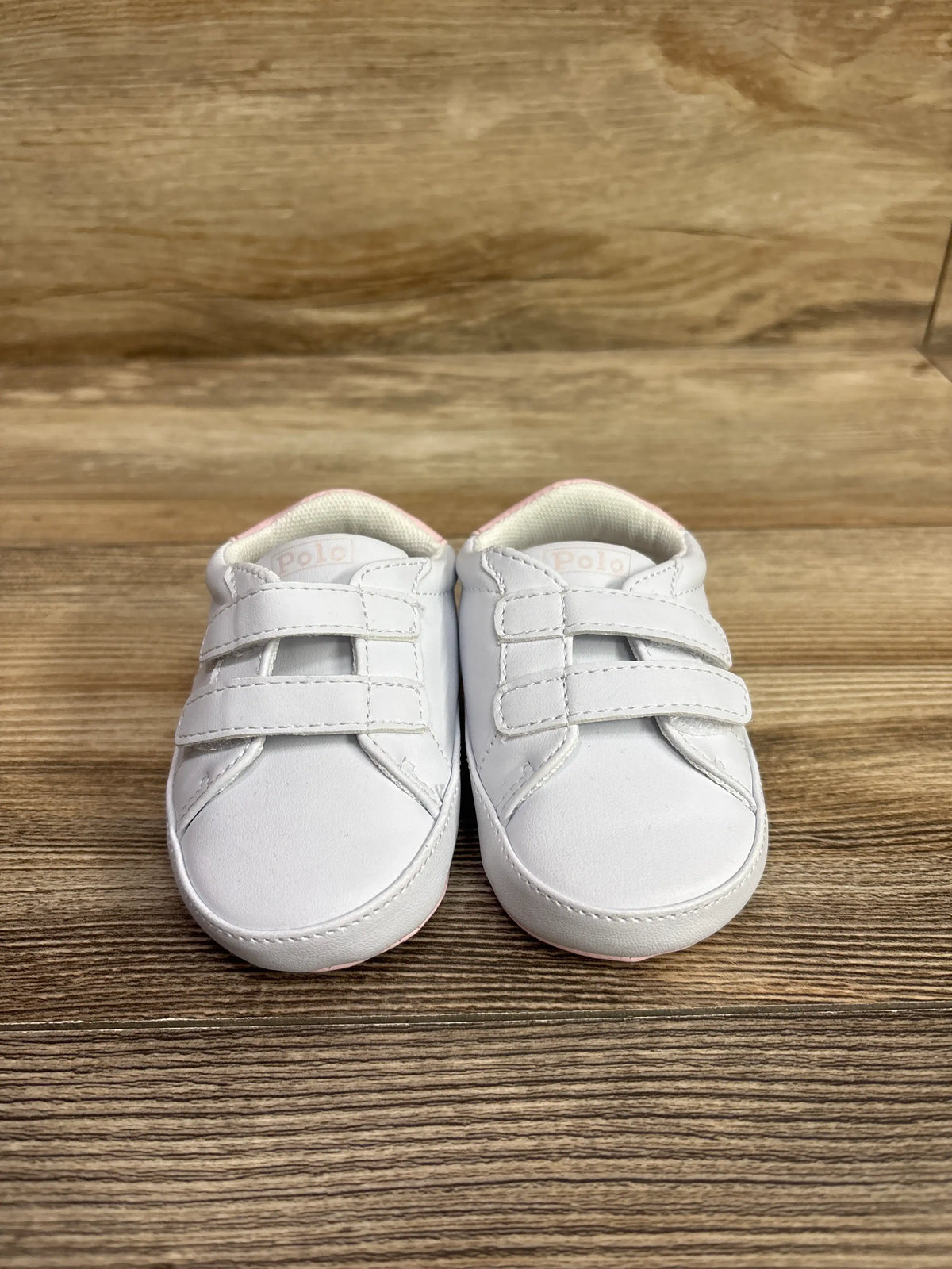 Front view of Polo Ralph Lauren Heritage Court II Ez crib sneakers showcasing white double straps on a wood floor