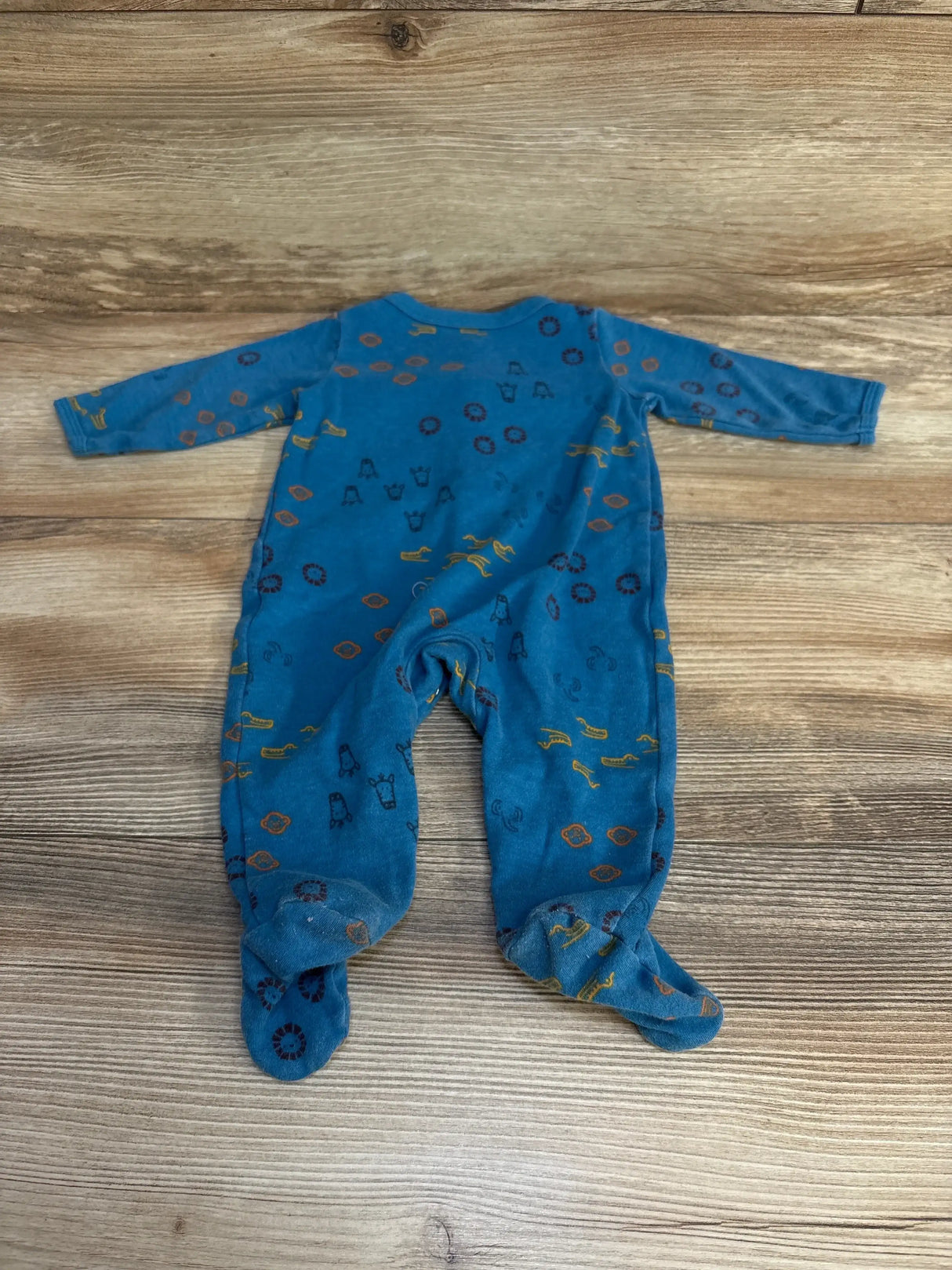 Back view of Carters animal print sleeper in blue size 3m showcasing footed long sleeve design with safari animal print on wood plank floor