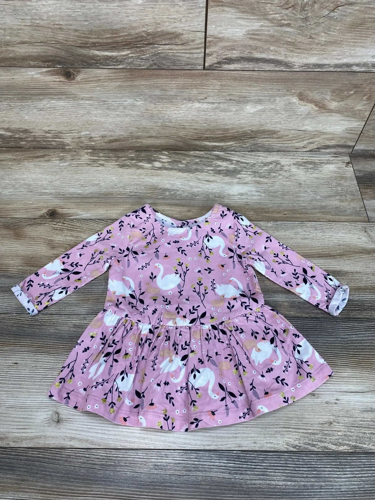 Front view of Anko baby swan dress in pink showcasing swan applique and ruffled skirt on white background