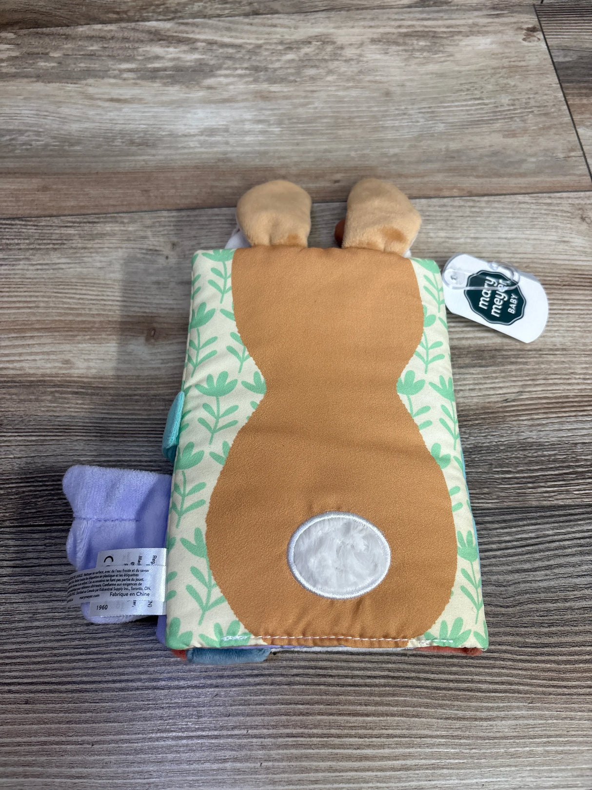 Back view of NEW Mary Meyer Leika Friends Soft Book showcasing plush deer cover and leaf-patterned fabric on wood background