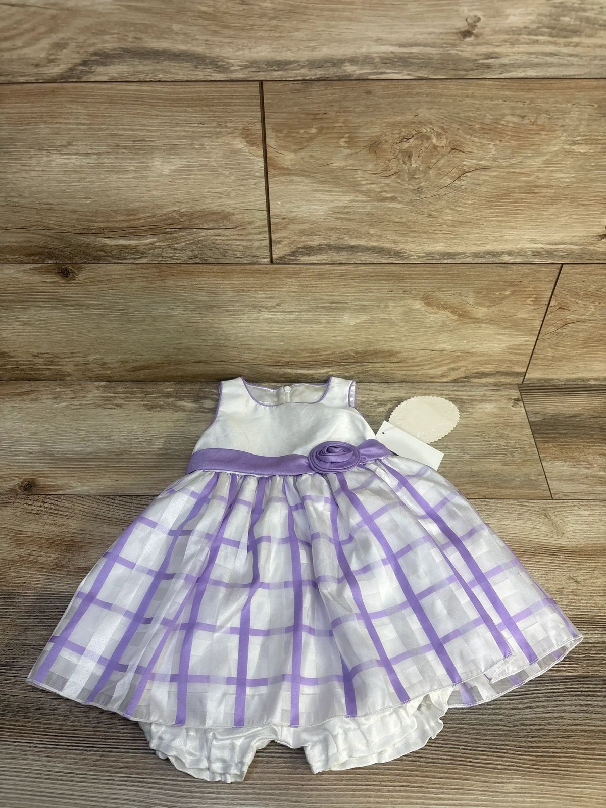 Front view of American Princess white sleeveless dress and bloomer shorts set with lavender plaid skirt on wood floor