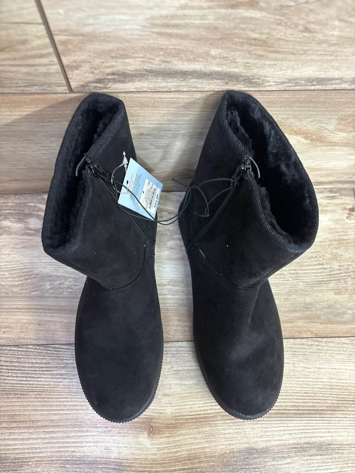 Kids black suede winter boots with faux fur lining on wooden floor
