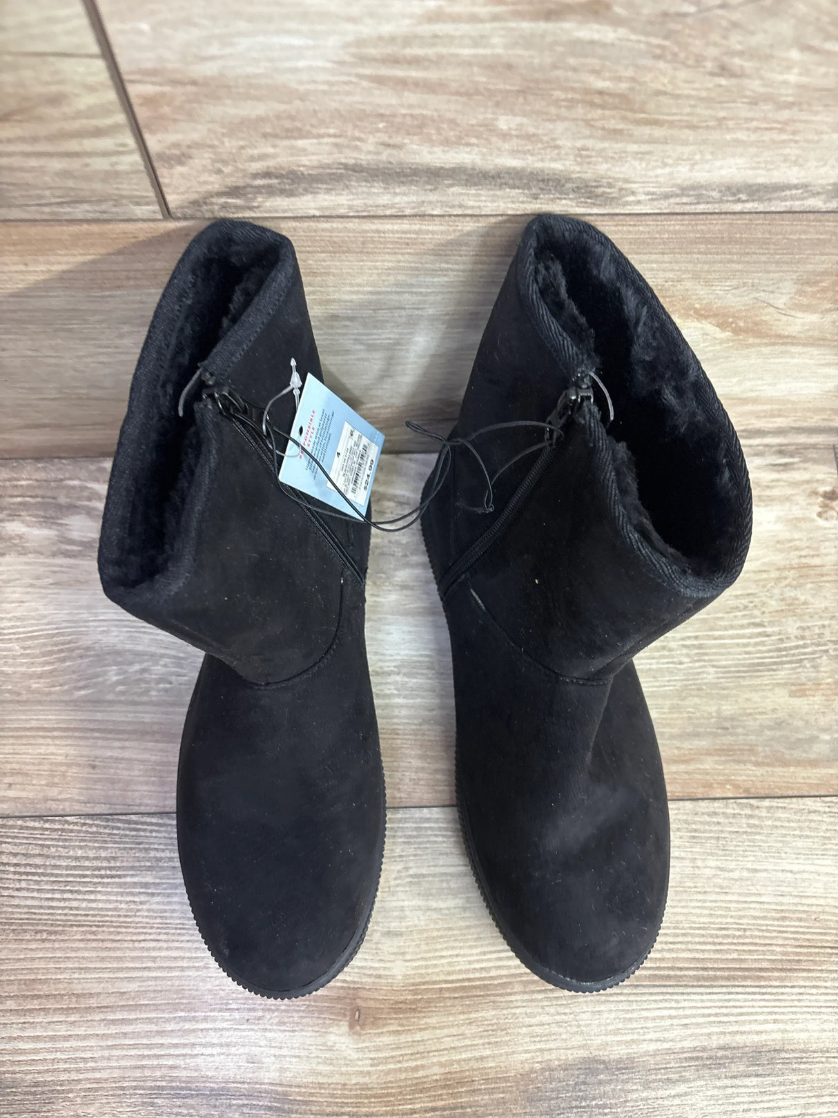 Kids black suede winter boots with faux fur lining on wooden floor