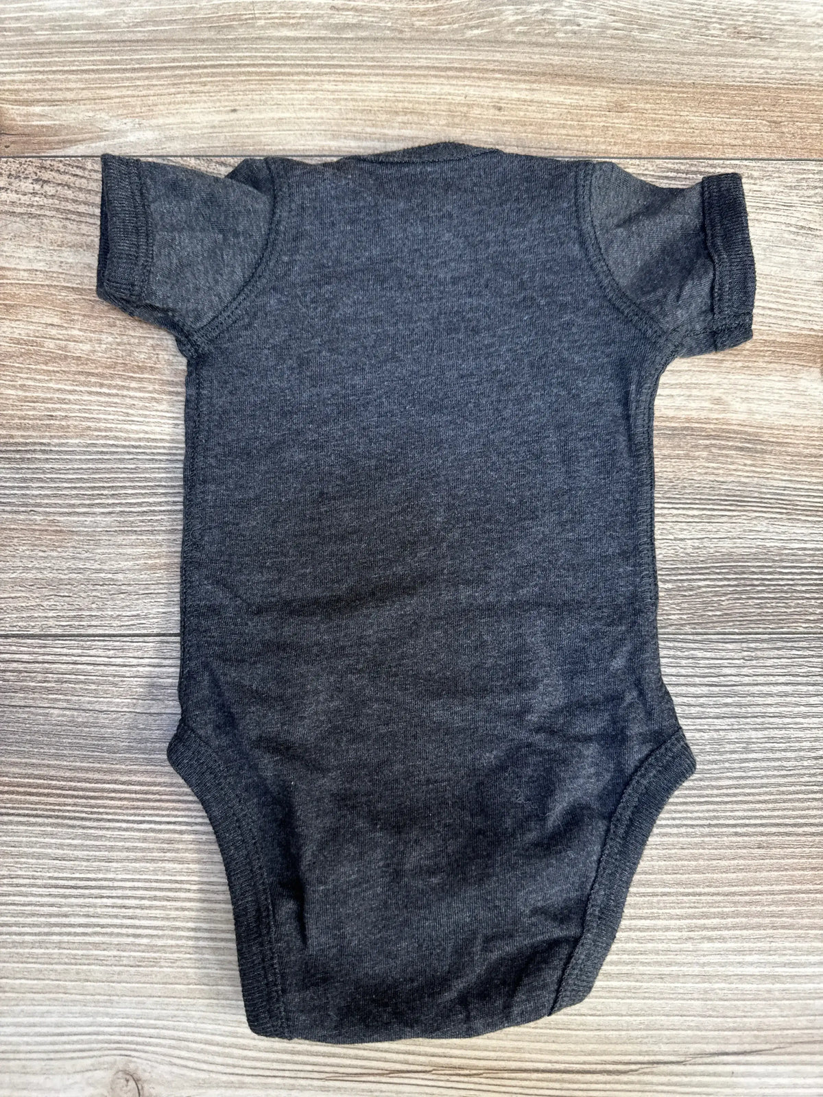 Back view of newborn charcoal baby bodysuit showcasing short sleeves and crew neckline on wood background
