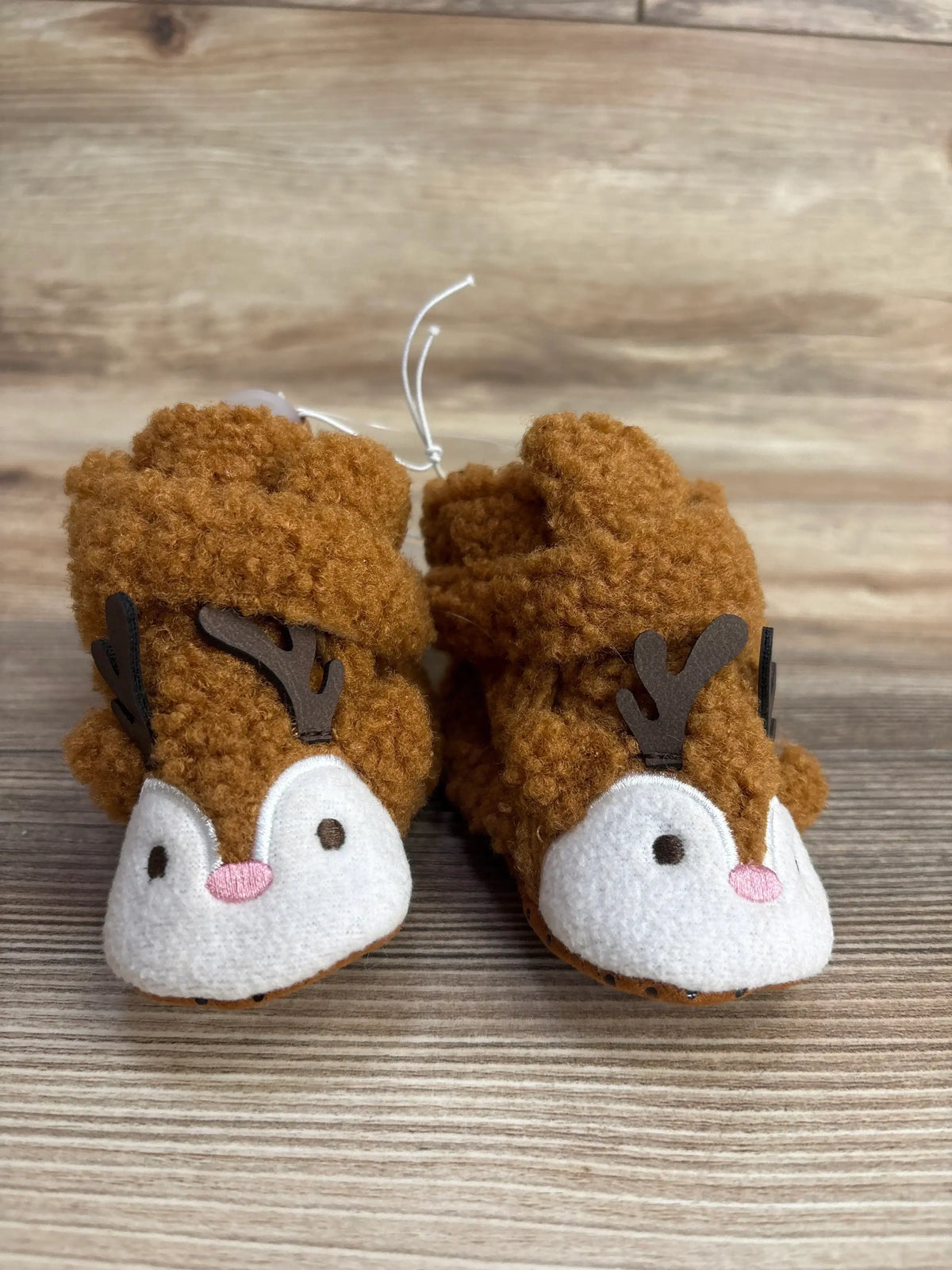 Adorable reindeer baby booties with soft brown fur, antlers, and pink noses, perfect for infants and toddlers.