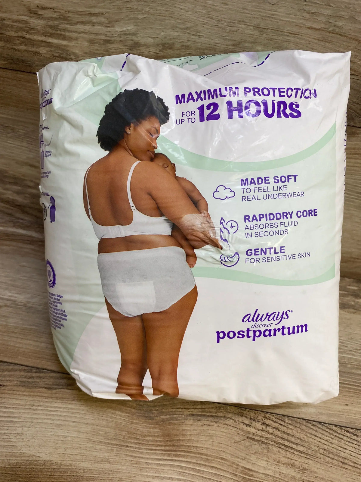 Front of Always Discreet postpartum 14-count pack showing model and ‘Maximum protection for up to 12 hours’ on wood floor