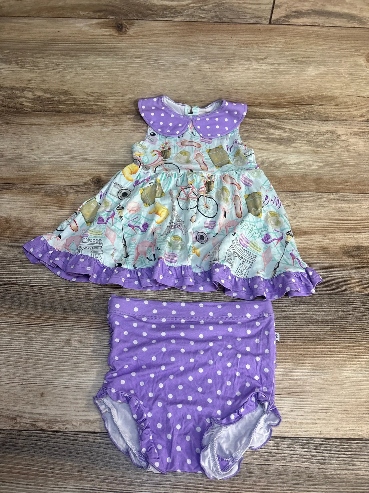 Front view of Birdie Bean Emilie Peplum Set sz 2T with peter pan collar and ruffle bummies on a wood floor