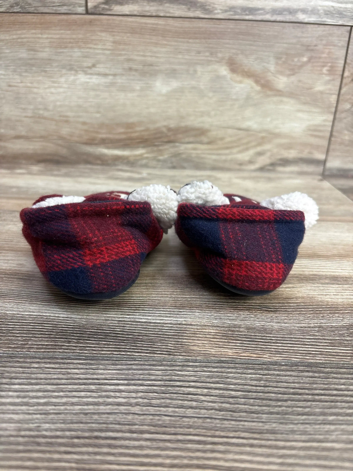 Front view of Dearfoams Lil Bear slippers size 5/6c showing red and navy plaid, white faux-fur lining and pom-poms on wood