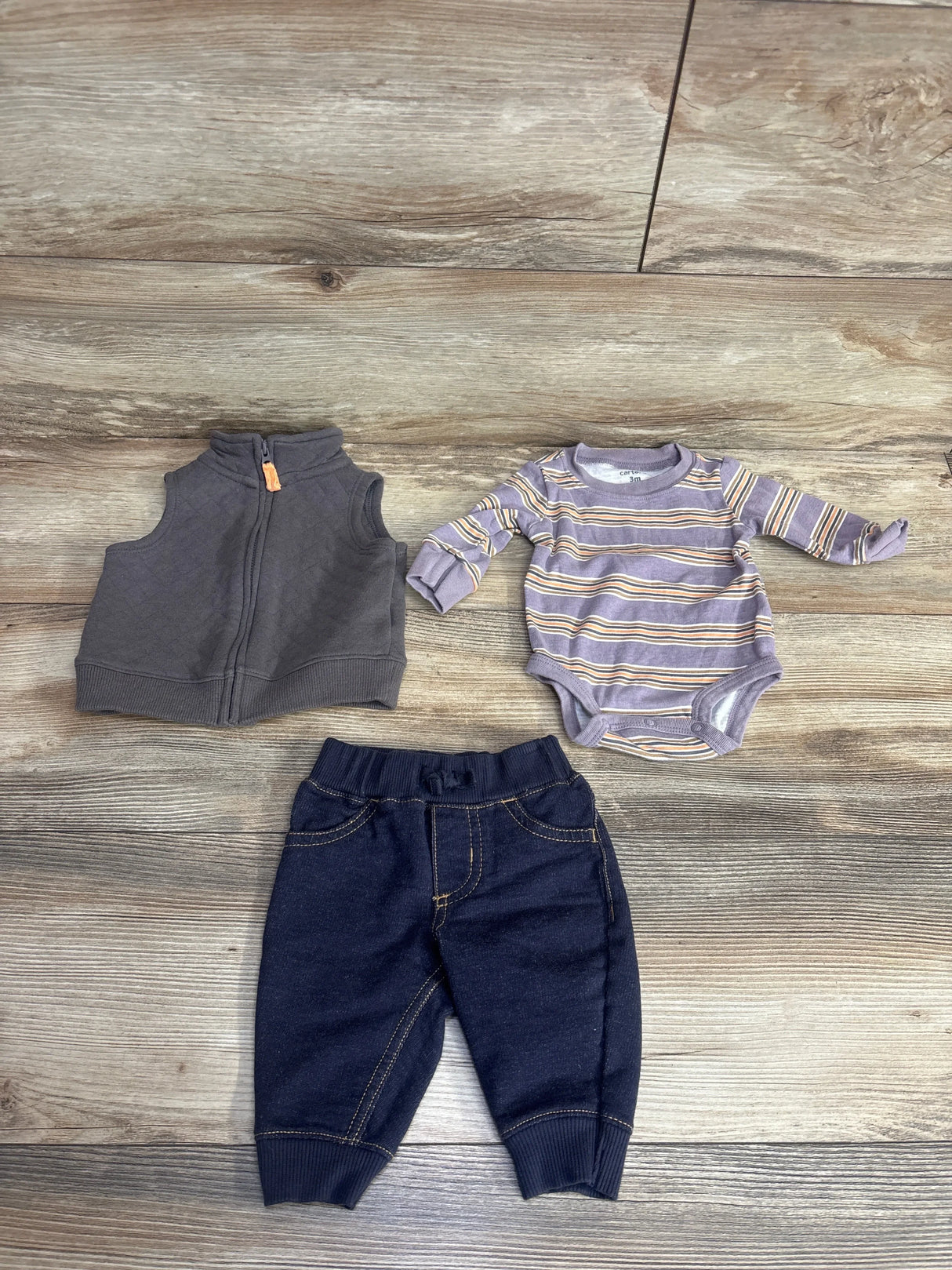 Baby boy outfit set with gray vest, striped long sleeve bodysuit, and dark pants on wood floor