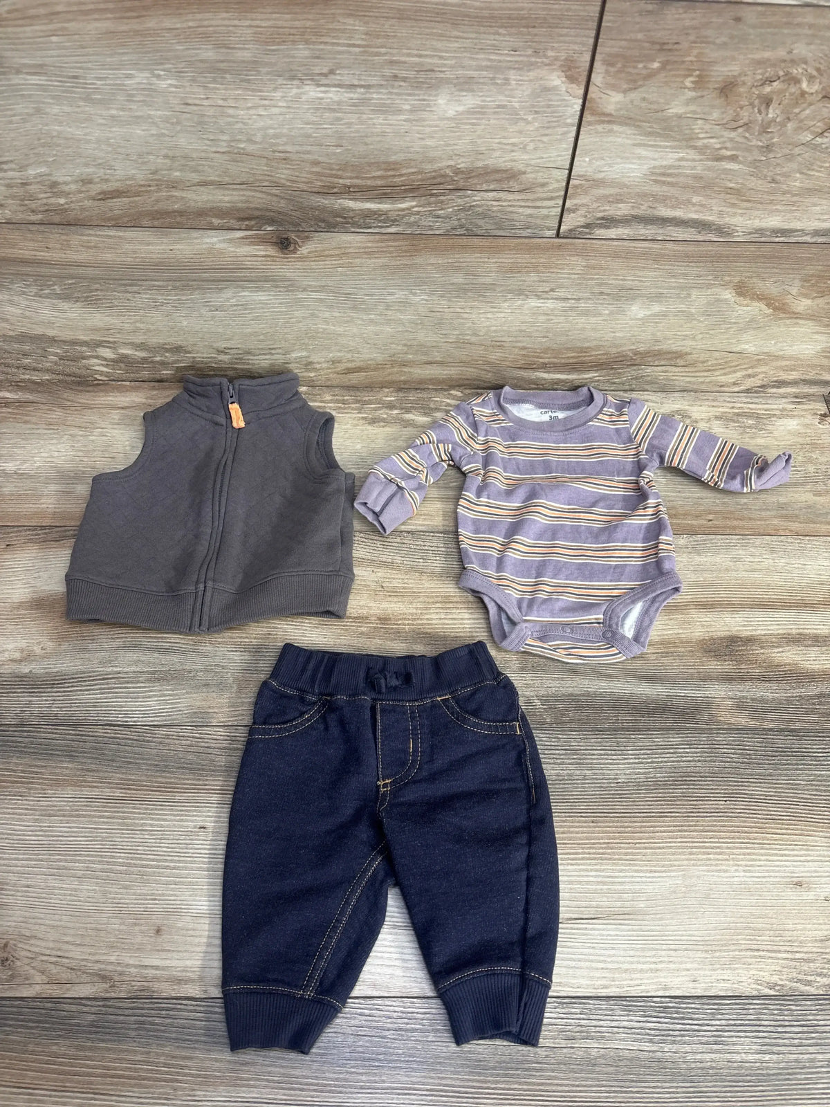 Baby boy outfit set with gray vest, striped long sleeve bodysuit, and dark pants on wood floor