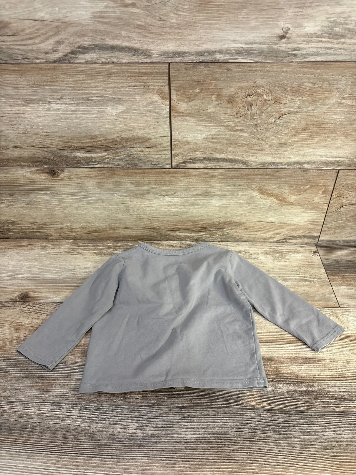 Back view of June & January grey button-front baby shirt, size 12-24 months, with long sleeves on wood plank background