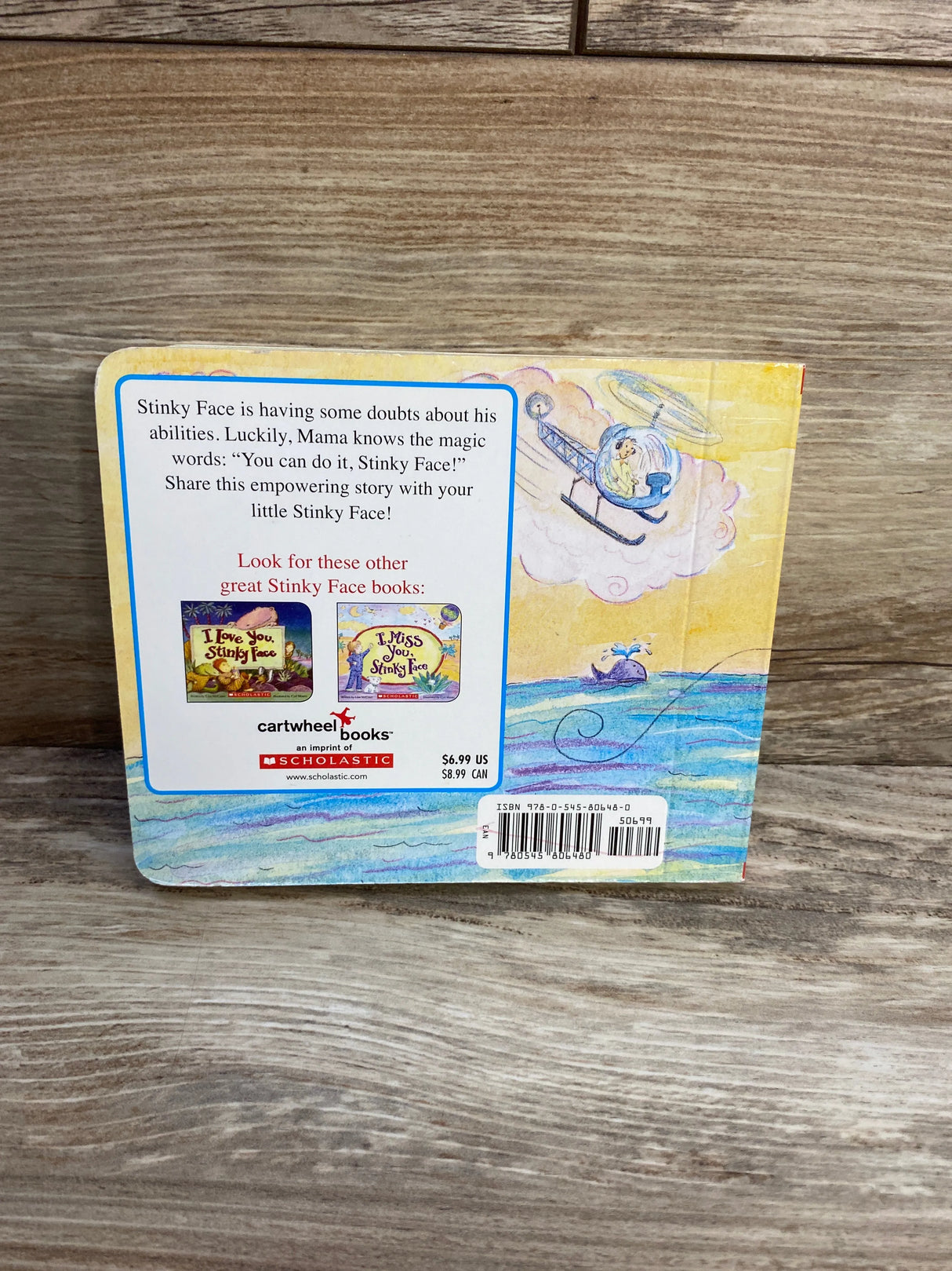 Back cover of Stinky Face children's book on wood, featuring helicopter illustration and book synopsis.