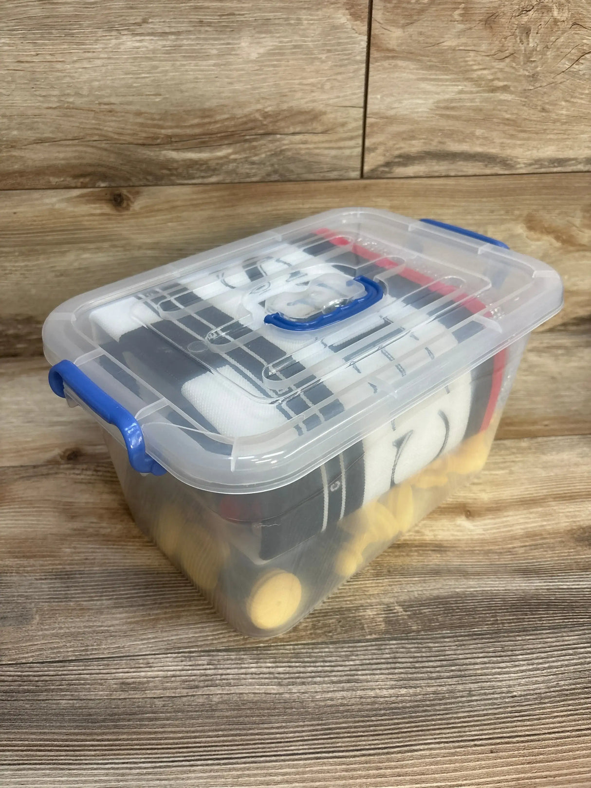 Three-quarter view of EasyGo giant chess set in clear plastic storage box showing yellow and black foam pieces on wood background