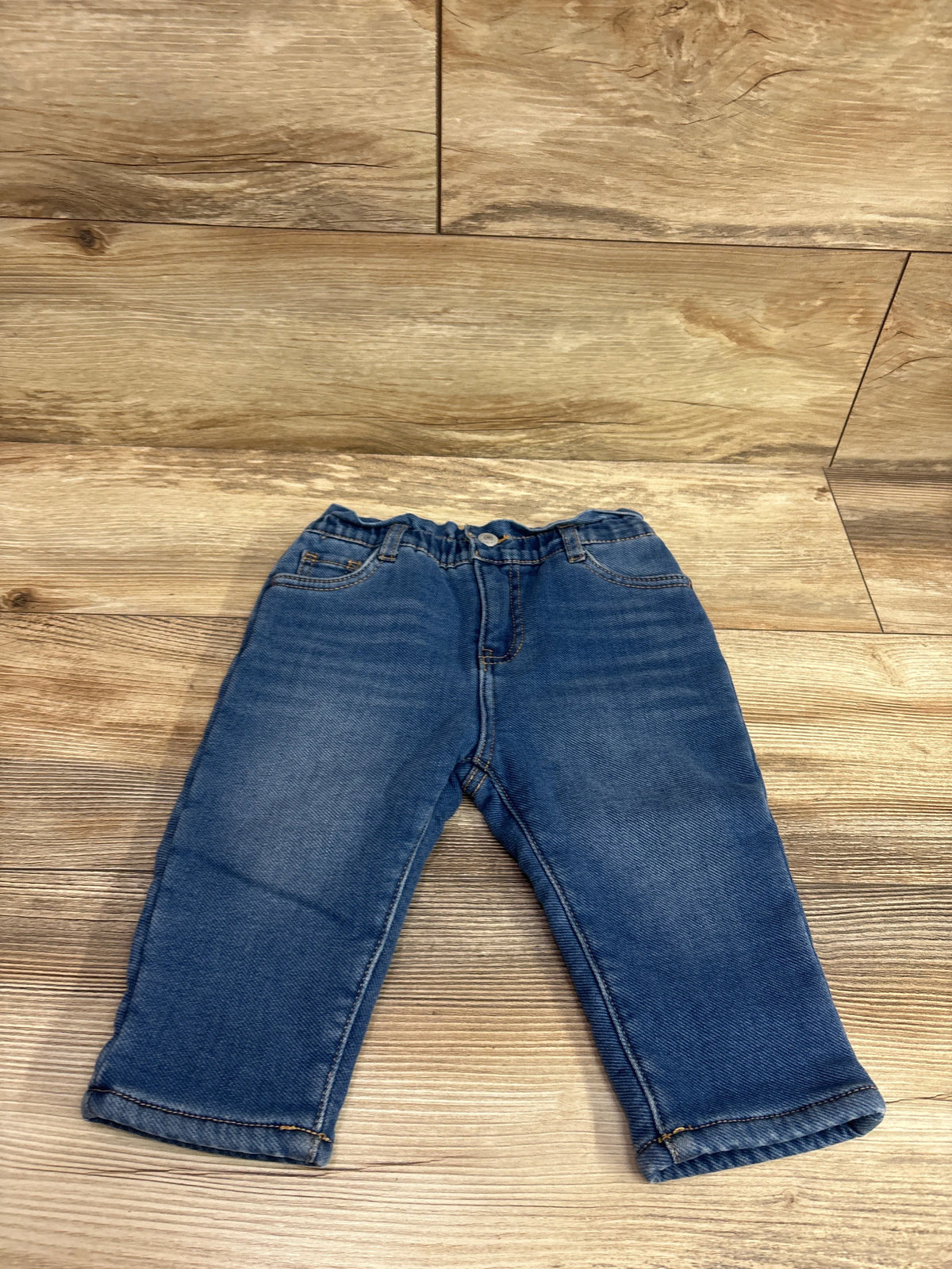 Front view of Levi’s High Loose Lined Jeans, blue size 12 months, with elastic waist and wide legs on a wood floor