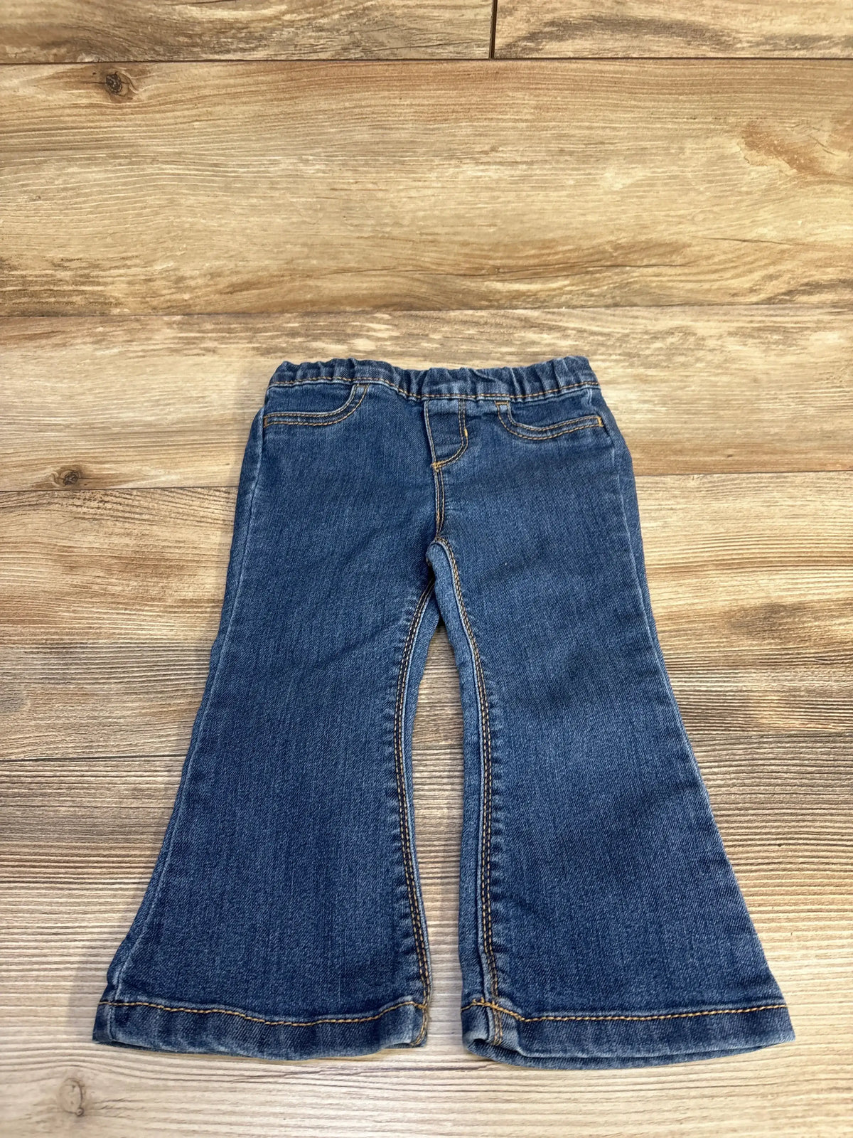 Front view of Carter’s navy toddler pull-on flare jeans, elastic waistband and flared legs, laid flat on wood background