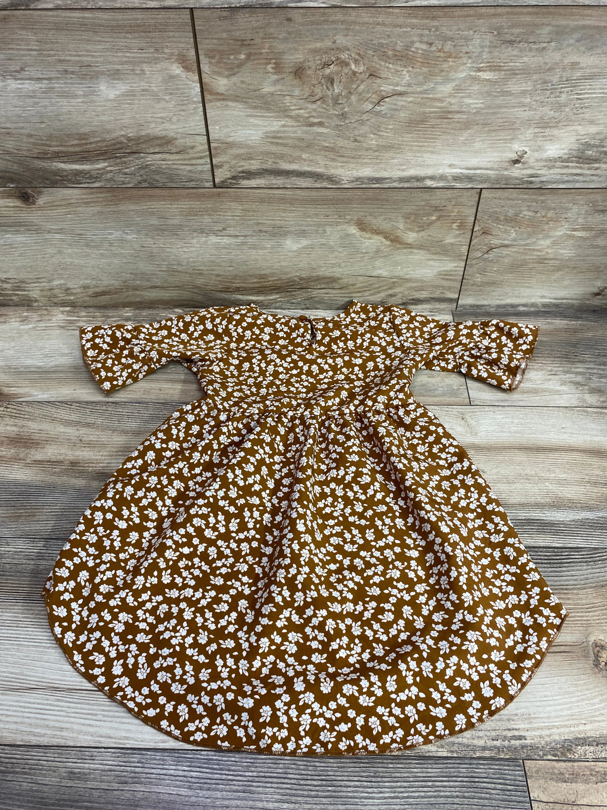 Front view of Bailey’s Blossoms brown floral dress in size 3T showcasing a gathered waist and full skirt on a wood floor
