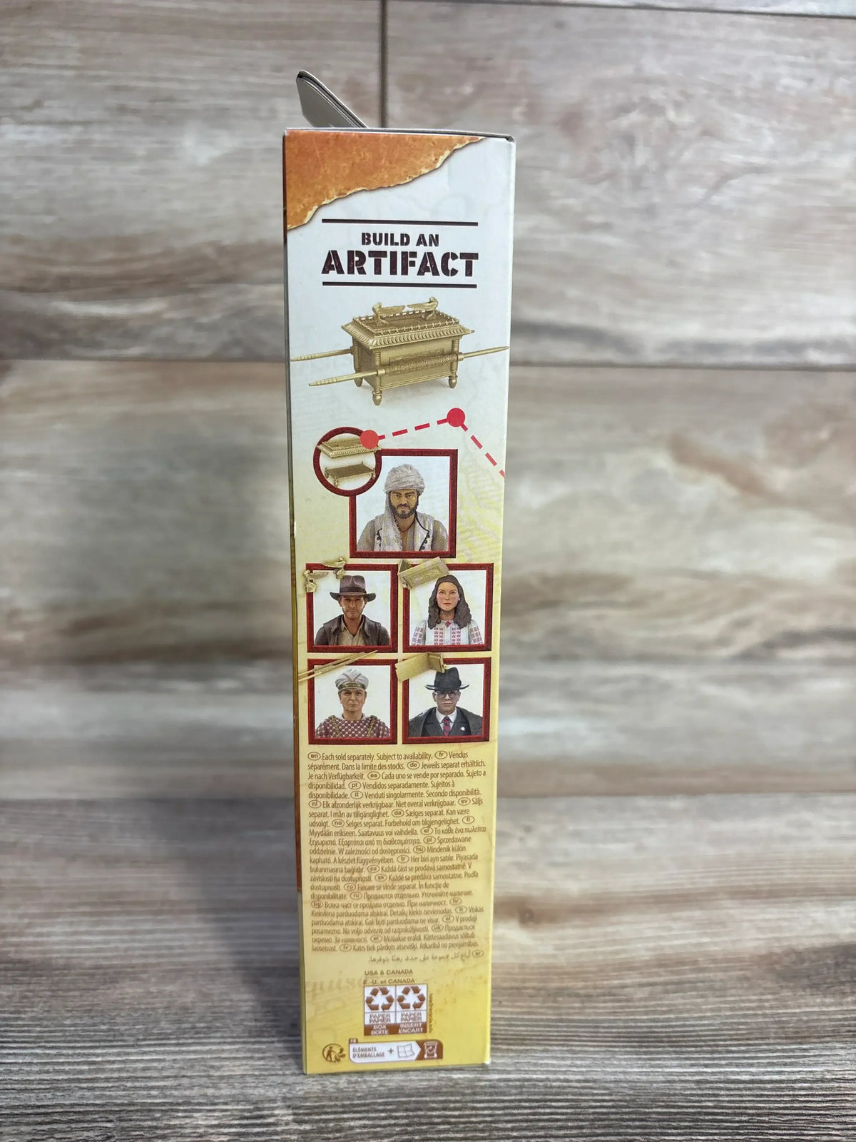Side of Sallah action figure box showing BUILD AN ARTIFACT, Ark illustration and character photos on wood background