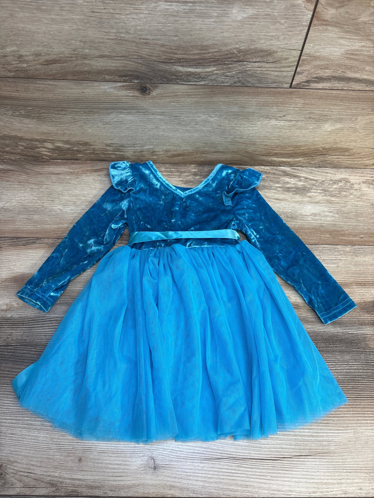 Blue velvet long sleeve toddler dress with tulle skirt on wood background