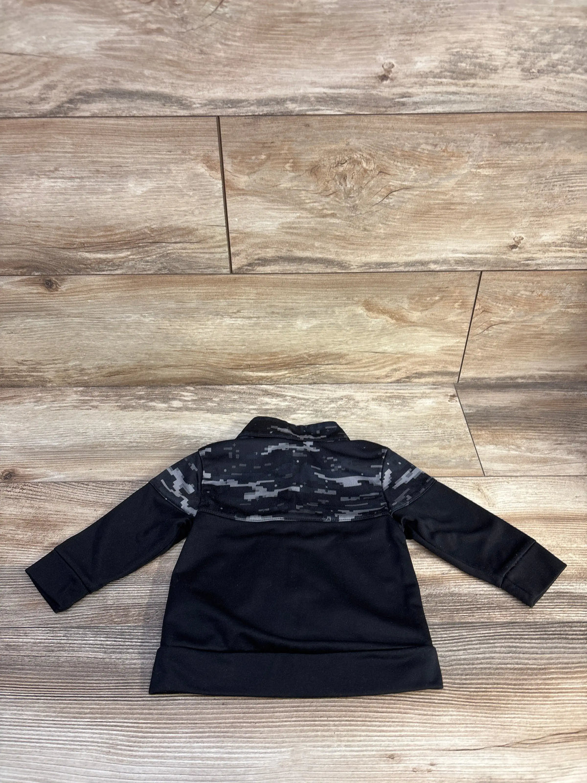 Back view of Athletic Works full zip active jacket in black, showcasing its gray camouflage upper panel and sleeves on a wood-grain floor