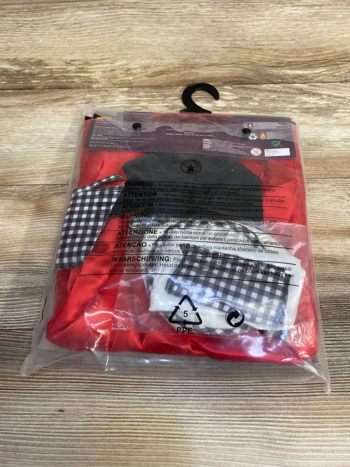 Red Diner Girl costume in clear packaging with a black-and-white checkered apron and matching neckerchief