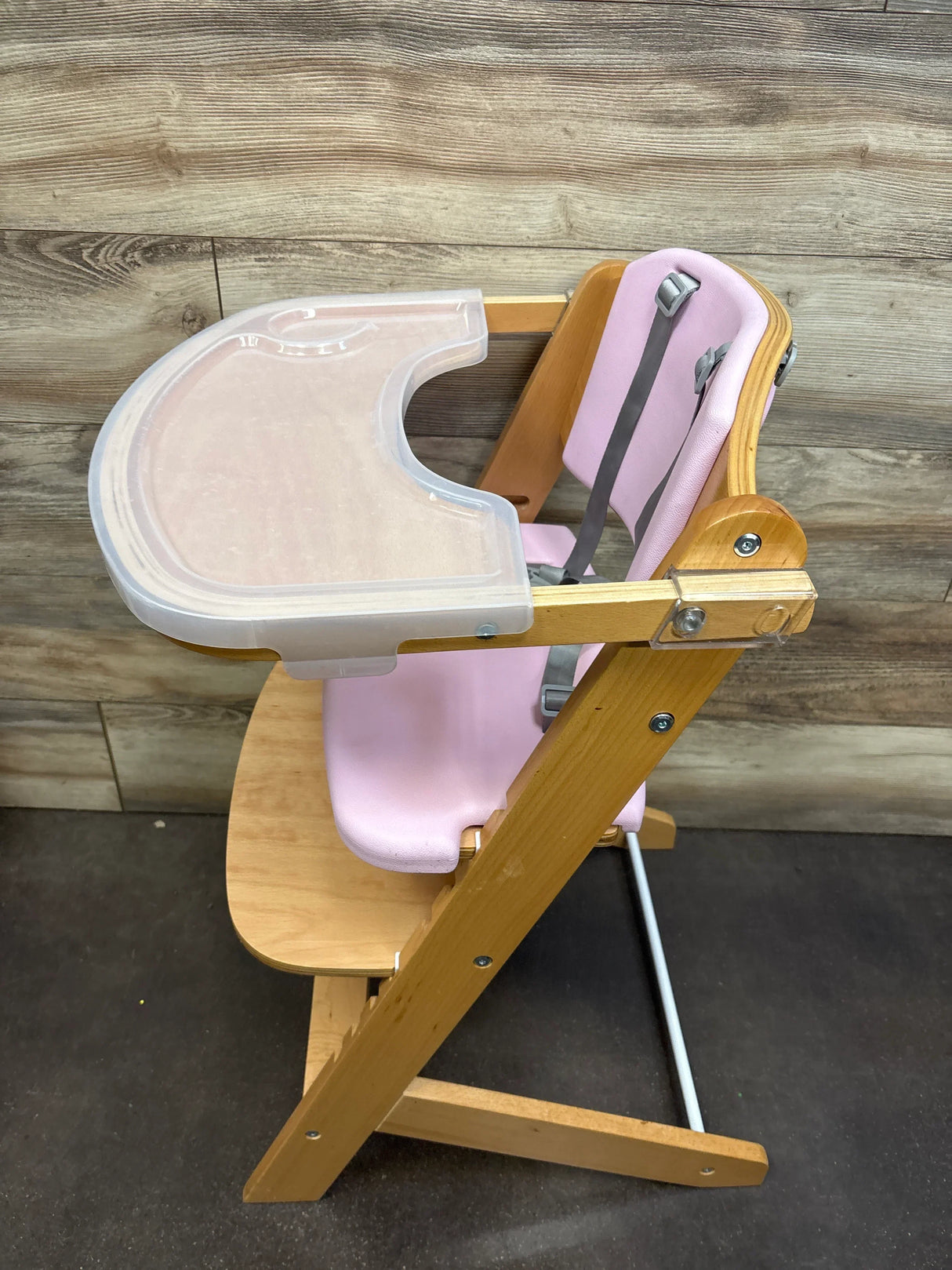 Side view of Cowiewie 3-in-1 natural wooden high chair showcasing adjustable frame, pink seat cushion, harness and clear tray